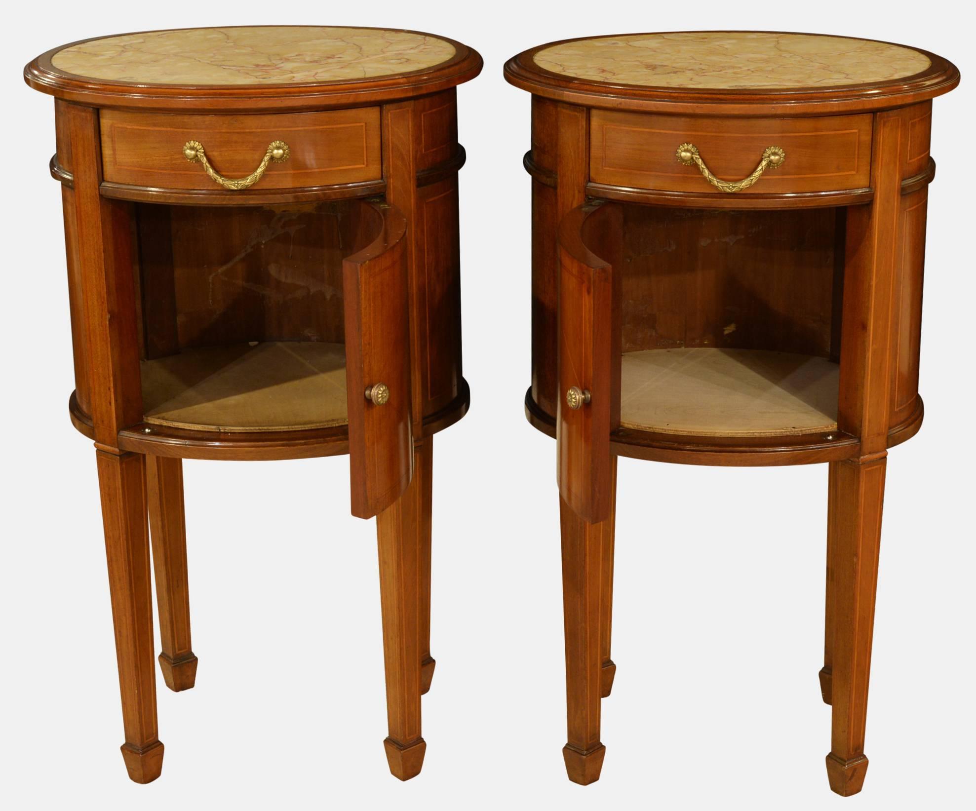 A pair of mahogany, oval line, inlaid bedside chests with inset marble tops,

circa 1900.