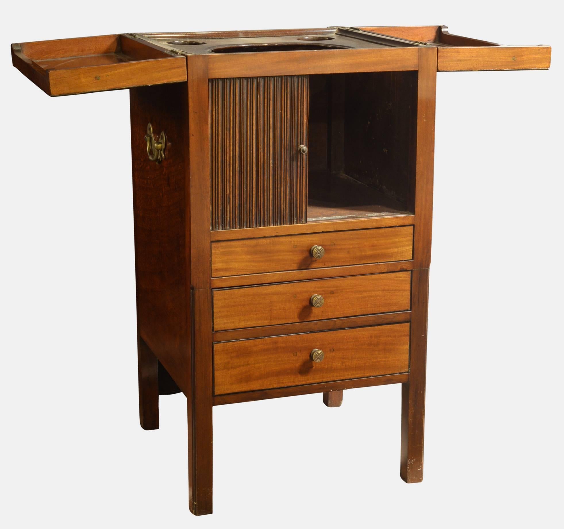 Georgian mahogany washstand with carrying handles and a tambour door. Three drawers and original interior with folded top.