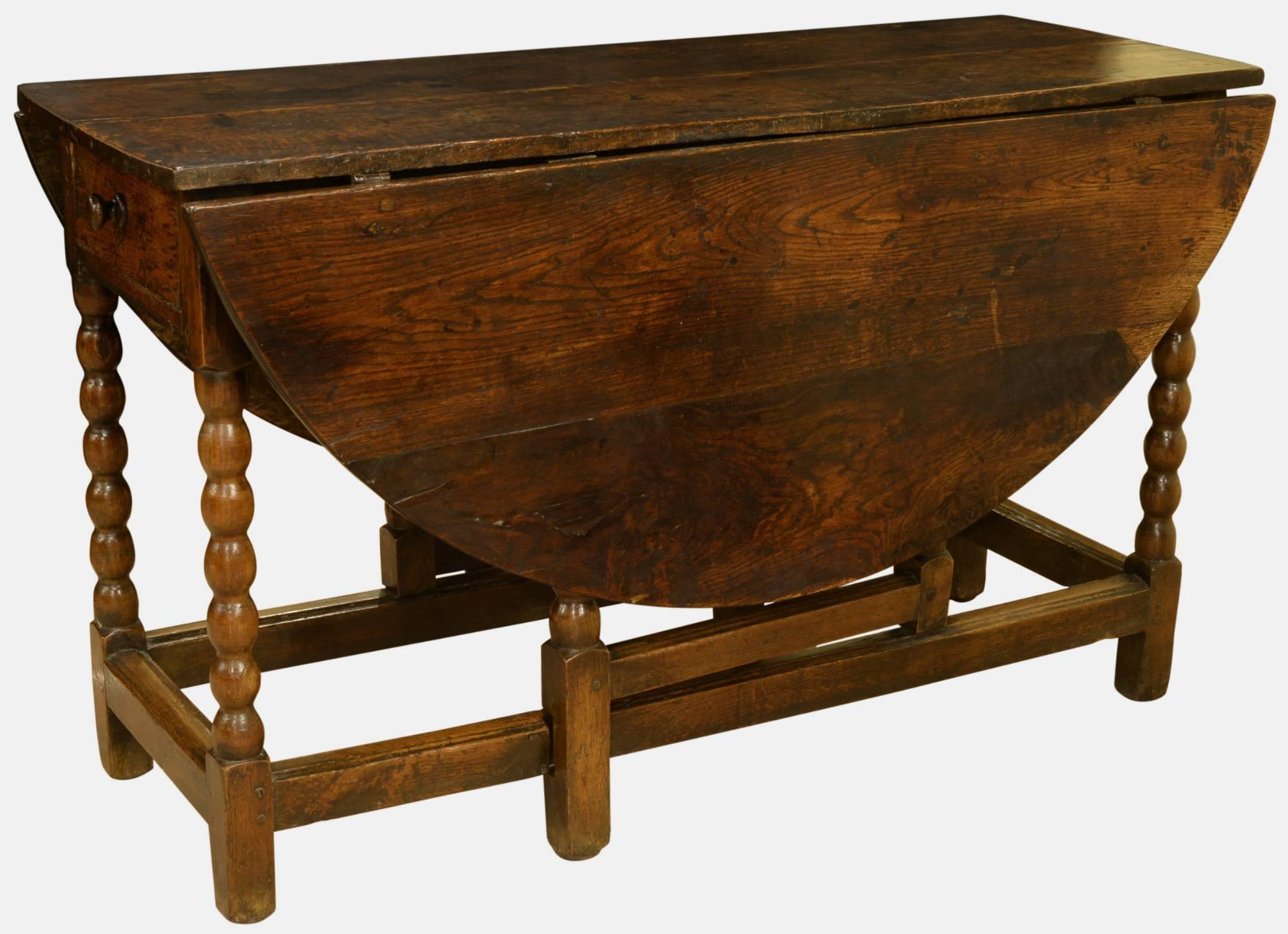 A large oak gateleg table with bobbin-turned legs and original drawer, 

circa 1680.