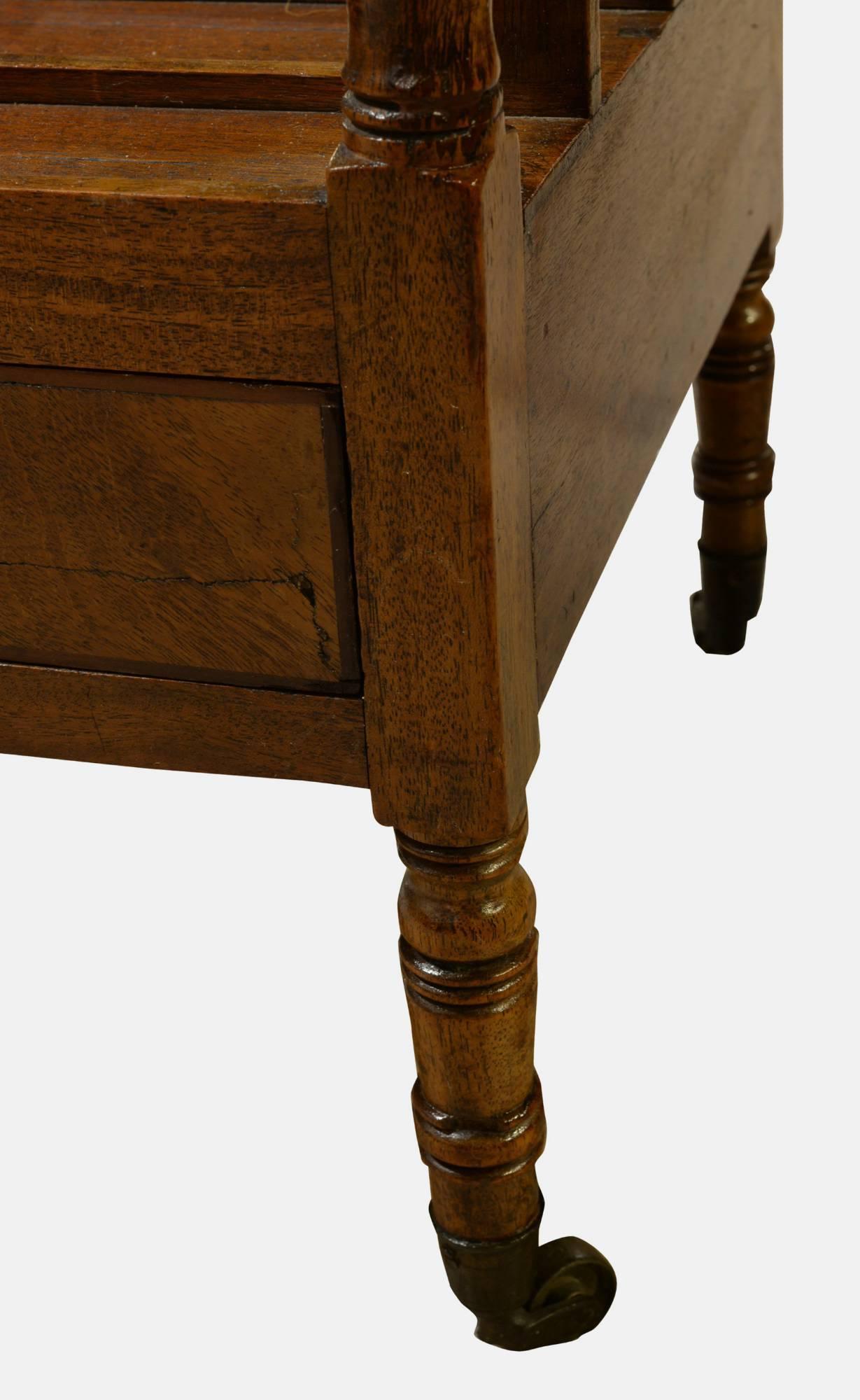 Regency Mahogany Canterbury with concave handle on turned supports and a single drawer.