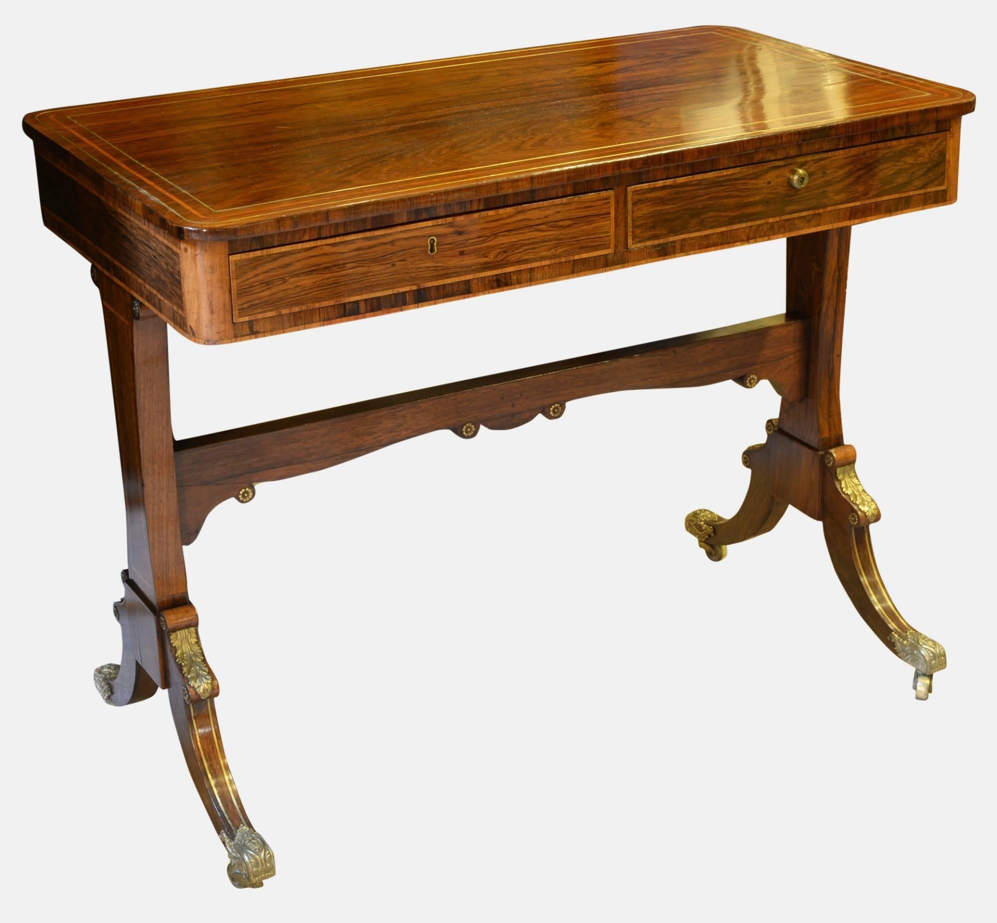 A Regency rosewood writing table on trestle end support with crossbanded decoration. Two free drawers at front and two dummy drawers at rear,

circa 1820.