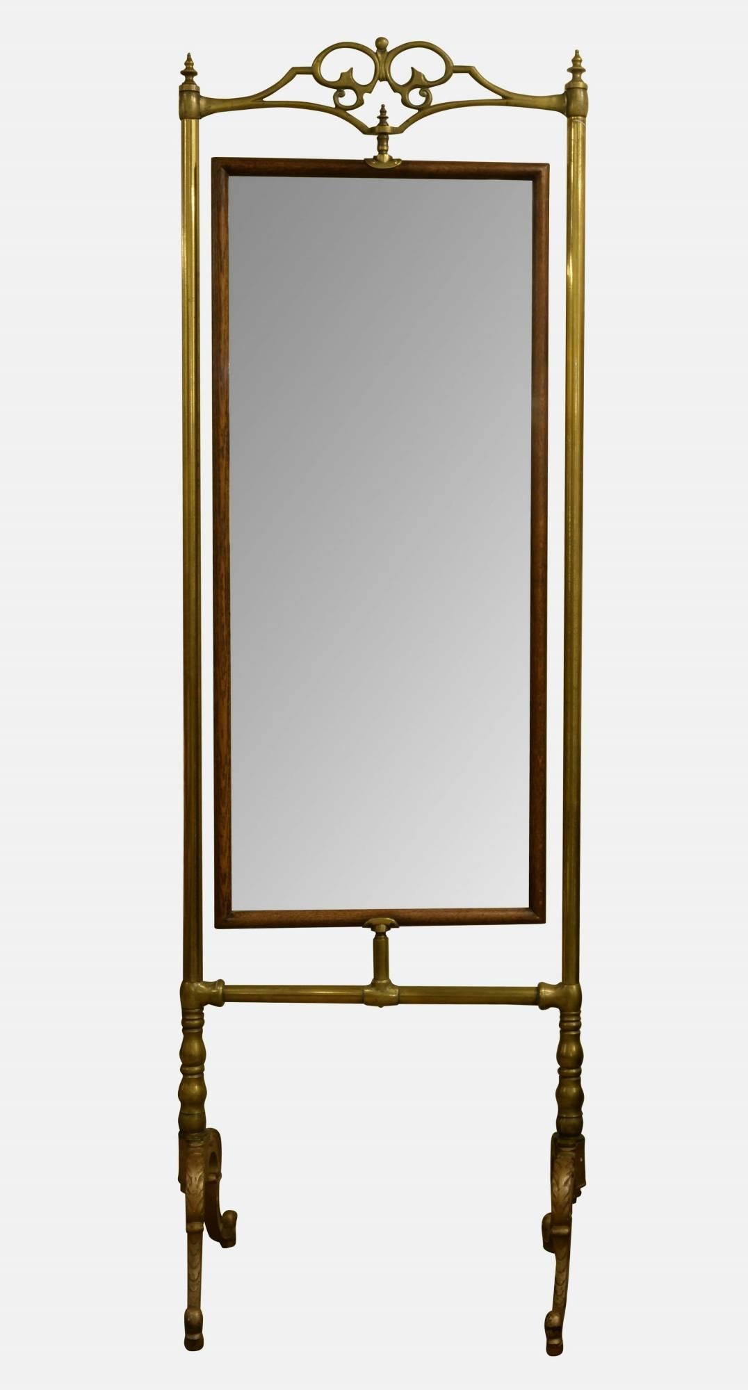 A late 19th century antique brass and oak dressing mirror with bevelled glass. Open pediment raised on scrolling supports.