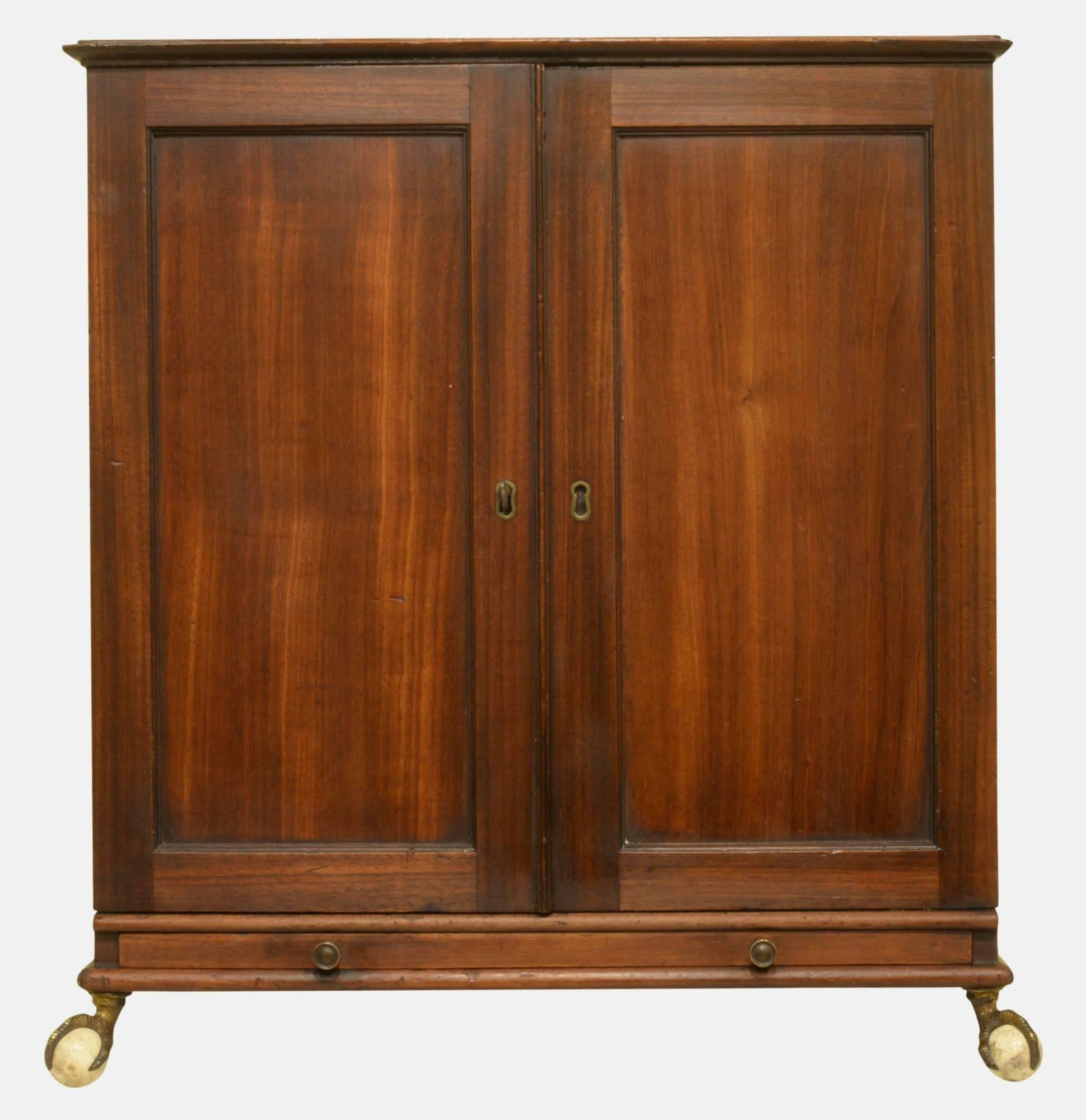 A Regency mahogany cabinet. The two panelled doors enclosing an arrangement of pigeon holes. Ball and claw feet.
 