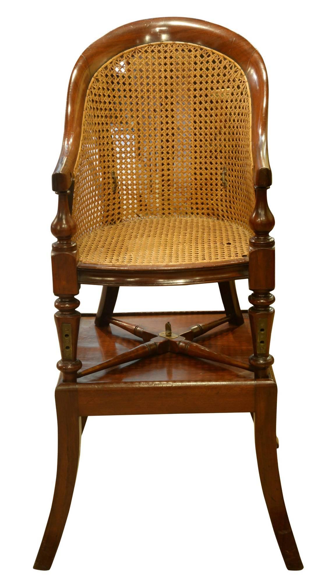 A William IV childs mahogany bergere high chair with swept back, turned legs and stretchers. Detachable from its original table stand,

circa 1830-1840.