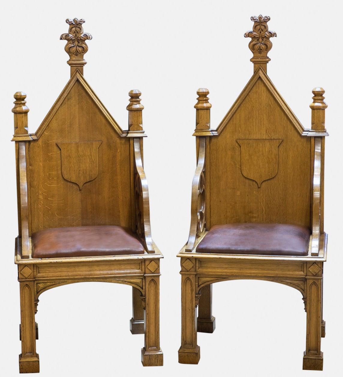 A pair of oak Gothic throne chairs with hand dyed leather seats.
In the style of AWN Pugin,

circa 1840.