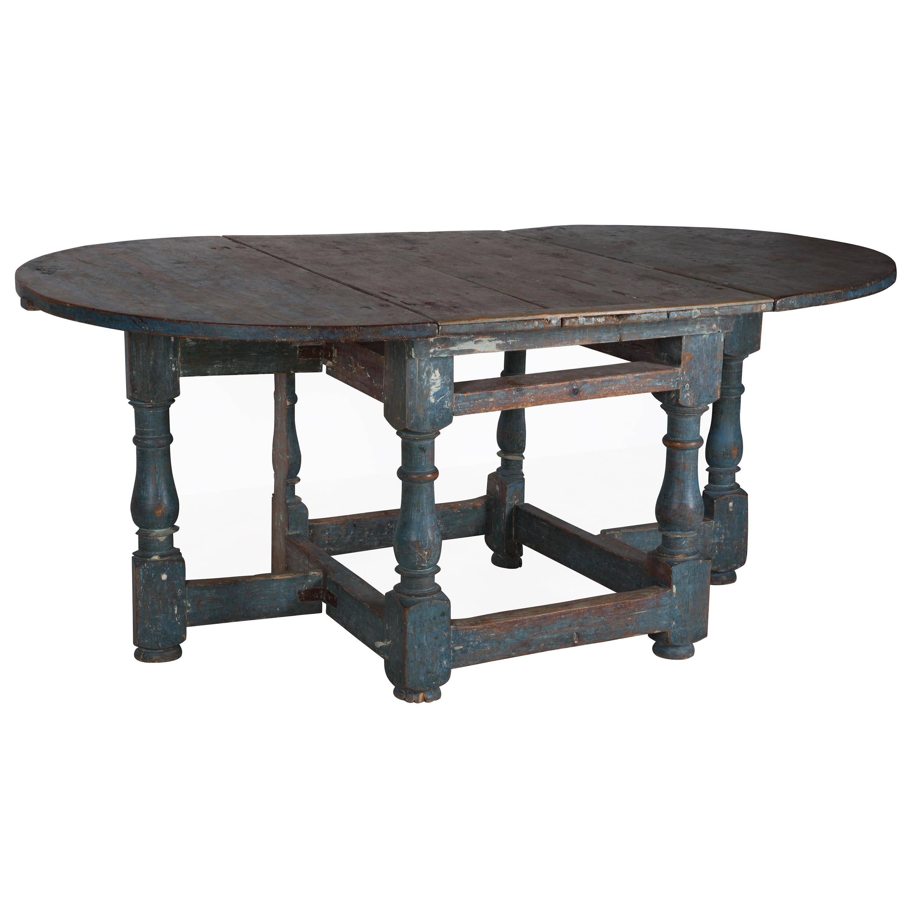 An 18th century Swedish Provincial drop-leaf dining or center table in traces of original paint (refreshed).