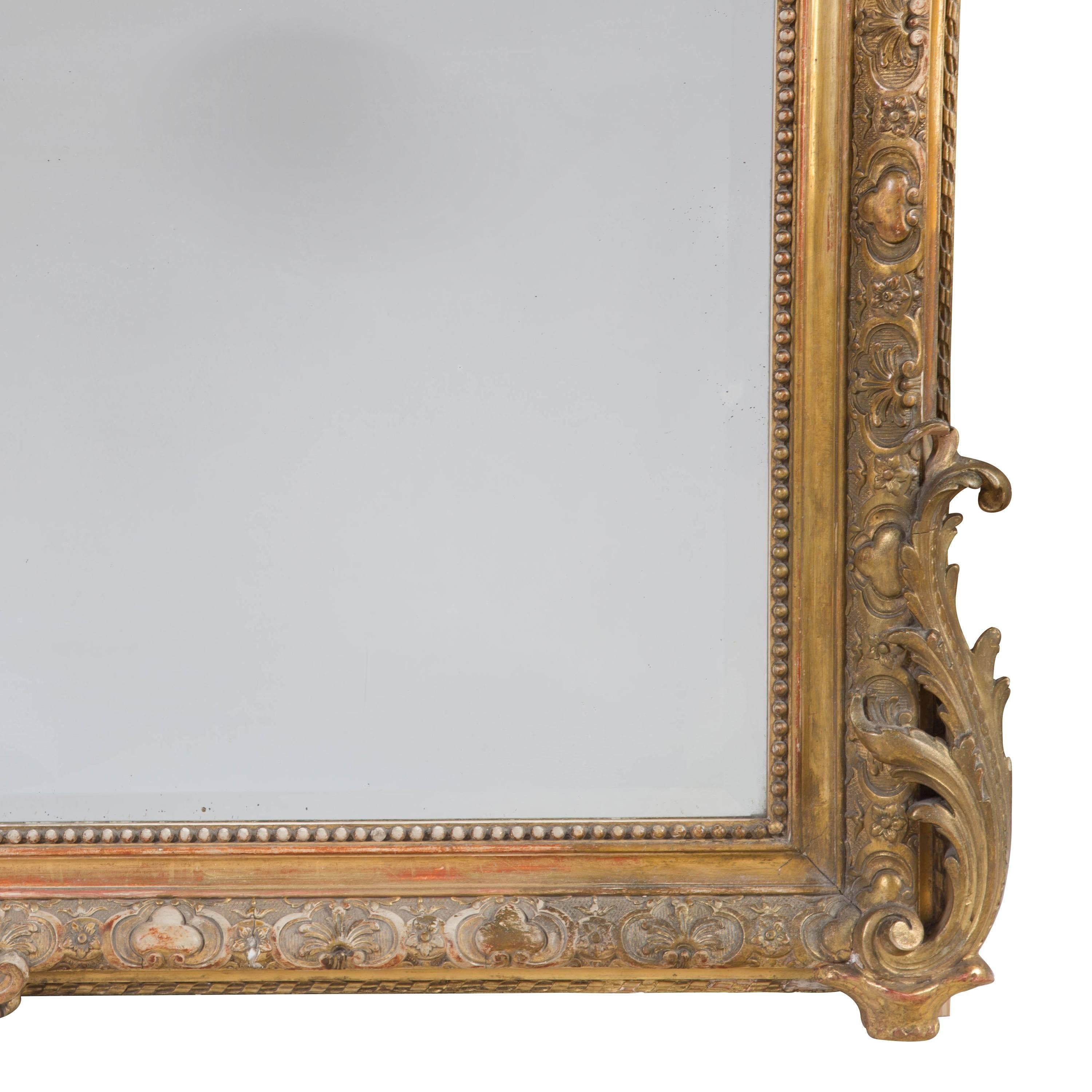 A large Louis XV revival giltwood and composition mirror with its original bevelled glass plate, with a shell cresting, French, circa 1875.