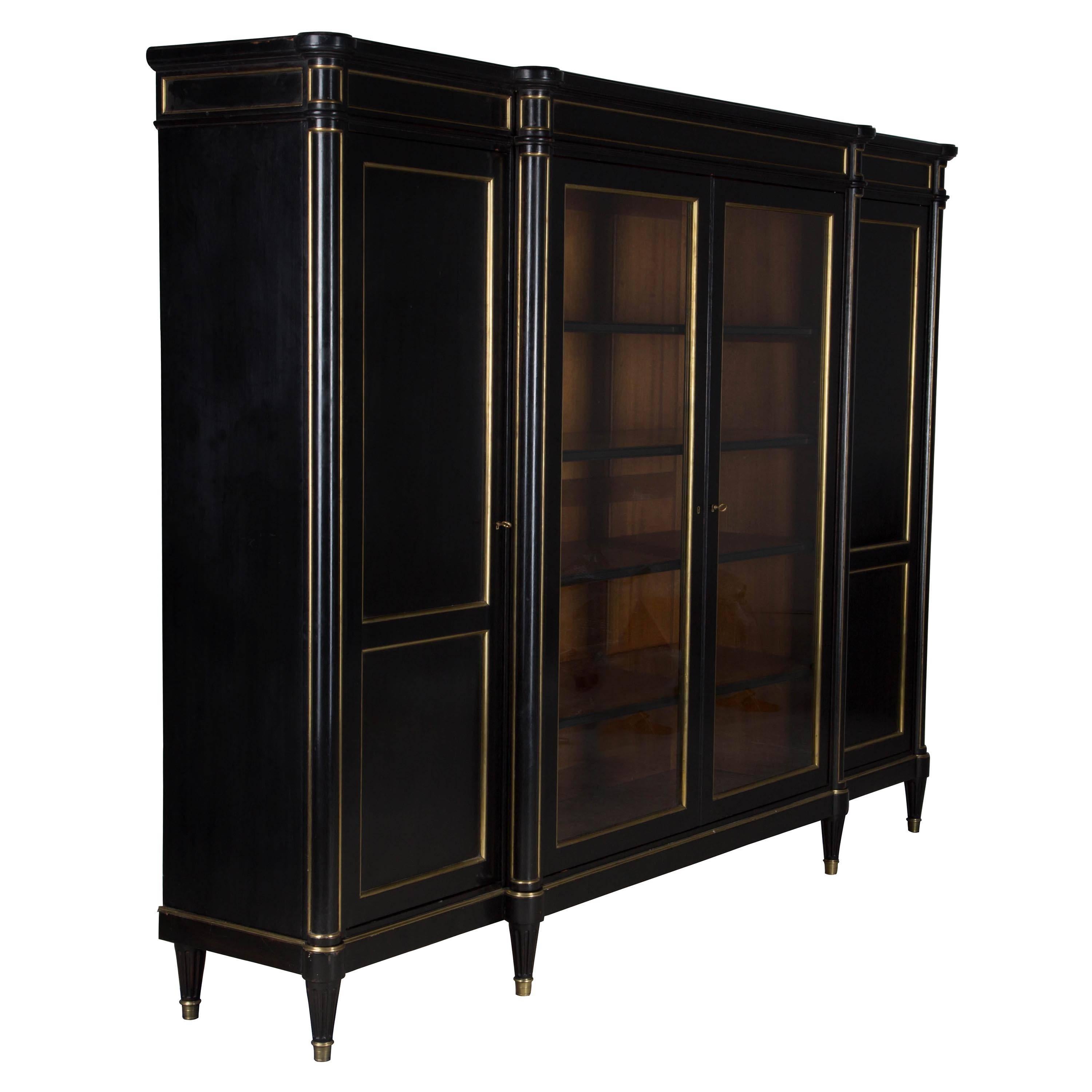 A wonderfully chic 1920s French ebonised mahogany 4-door bookcase with brass mounts.