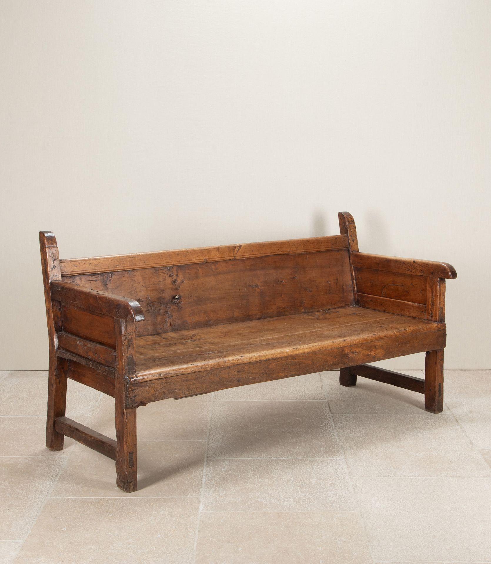 Large 18th Century Spanish bench of solid walnut construction. With signs of its original hand carved elements, displaying a wonderfully primitive aesthetic.