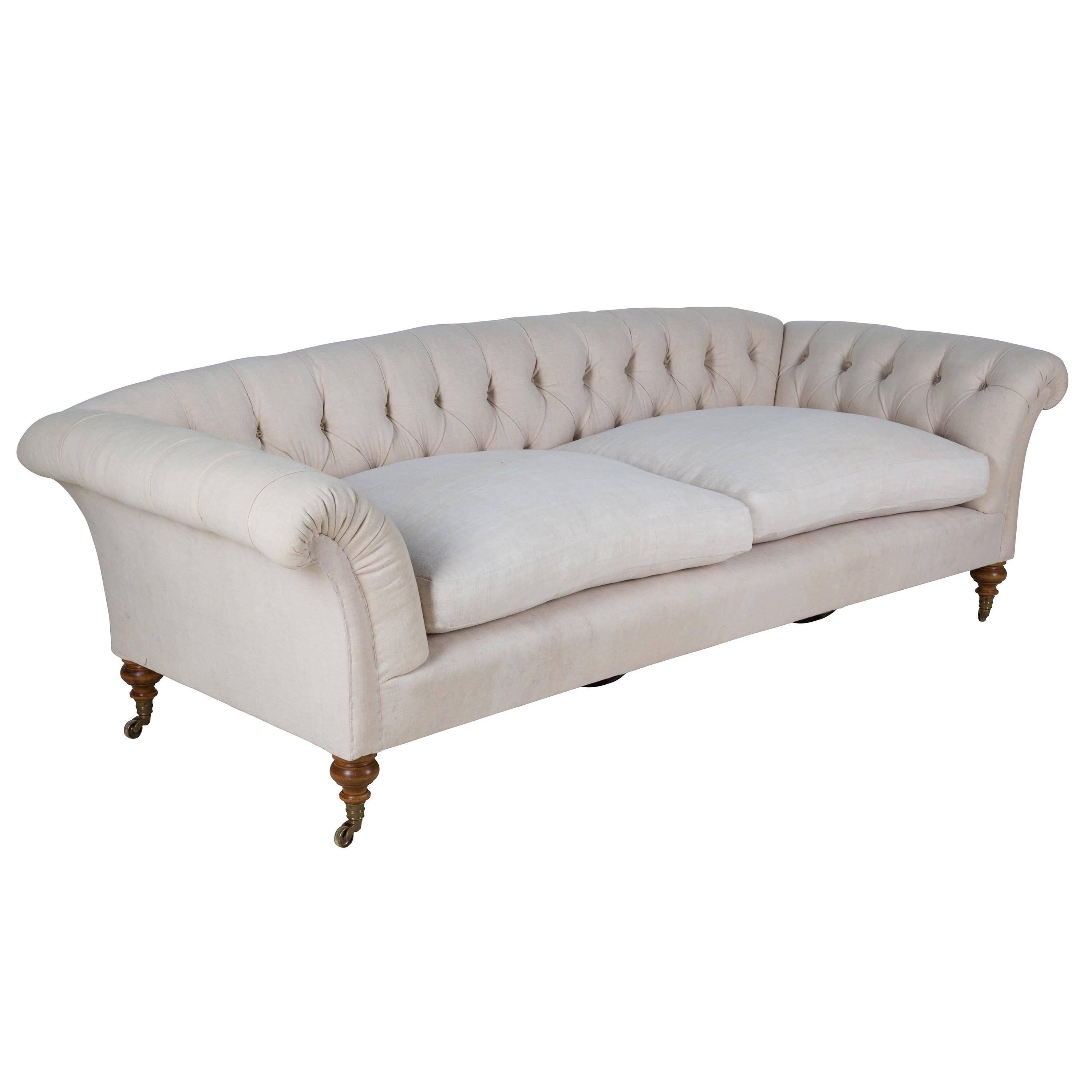 This sofa is a copy of an early Howard and Sons sofa. Made in England using a hard wood beech frame. Traditionally upholstered with hand-sewn horse hair throughout, sprung seat and down cushions. The legs are hand-turned with lost-wax brass casters.