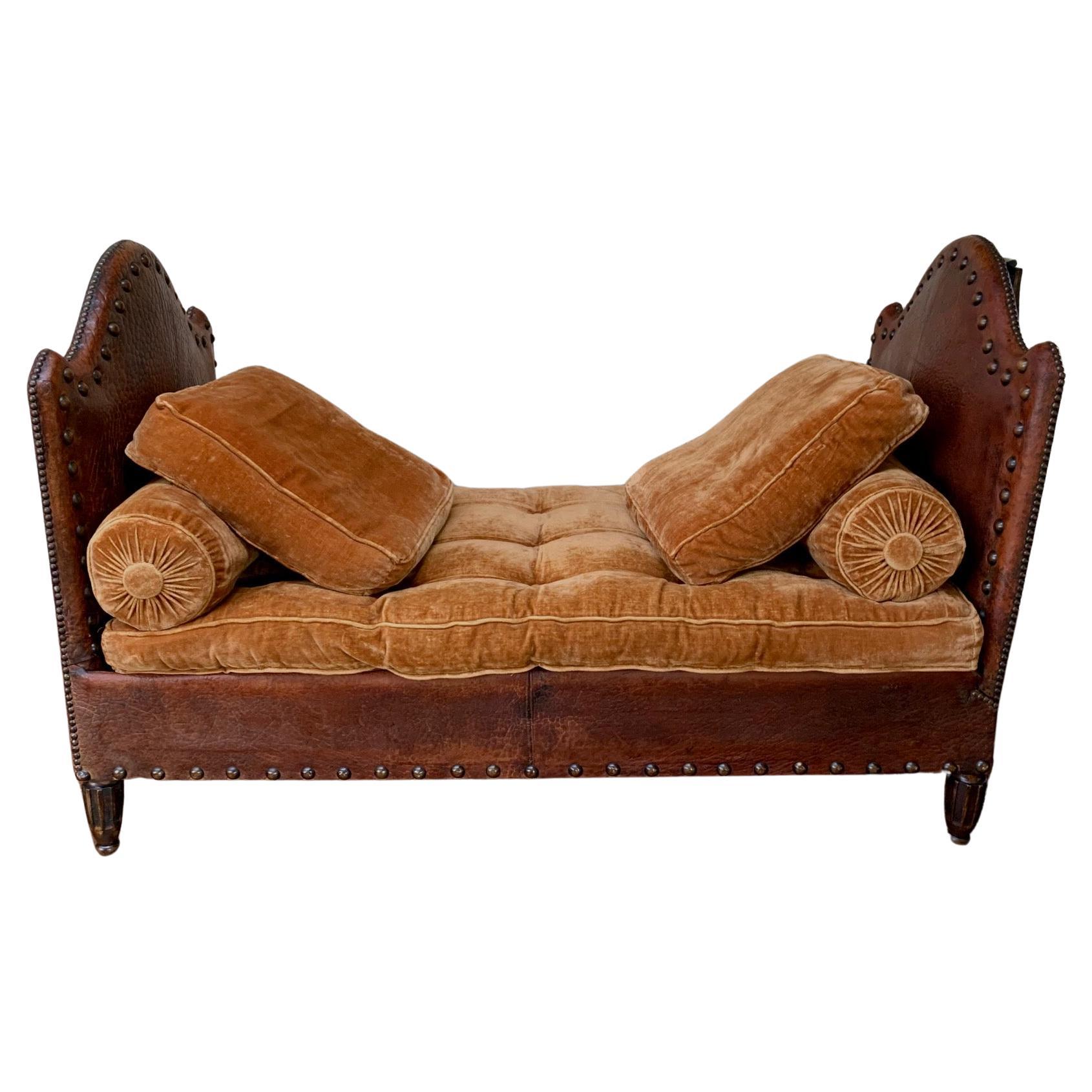 This exquisite French banquette is in the most extraordinary condition for its age. The leather is completely original and it still retains its burnt orange cotton velvet, seat cushion and matching ruched bolsters. The overall visual effect is just