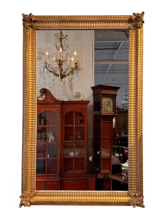 Specchio in legno dorato in stile Luigi XVI con angoli decorati a motivi floreali