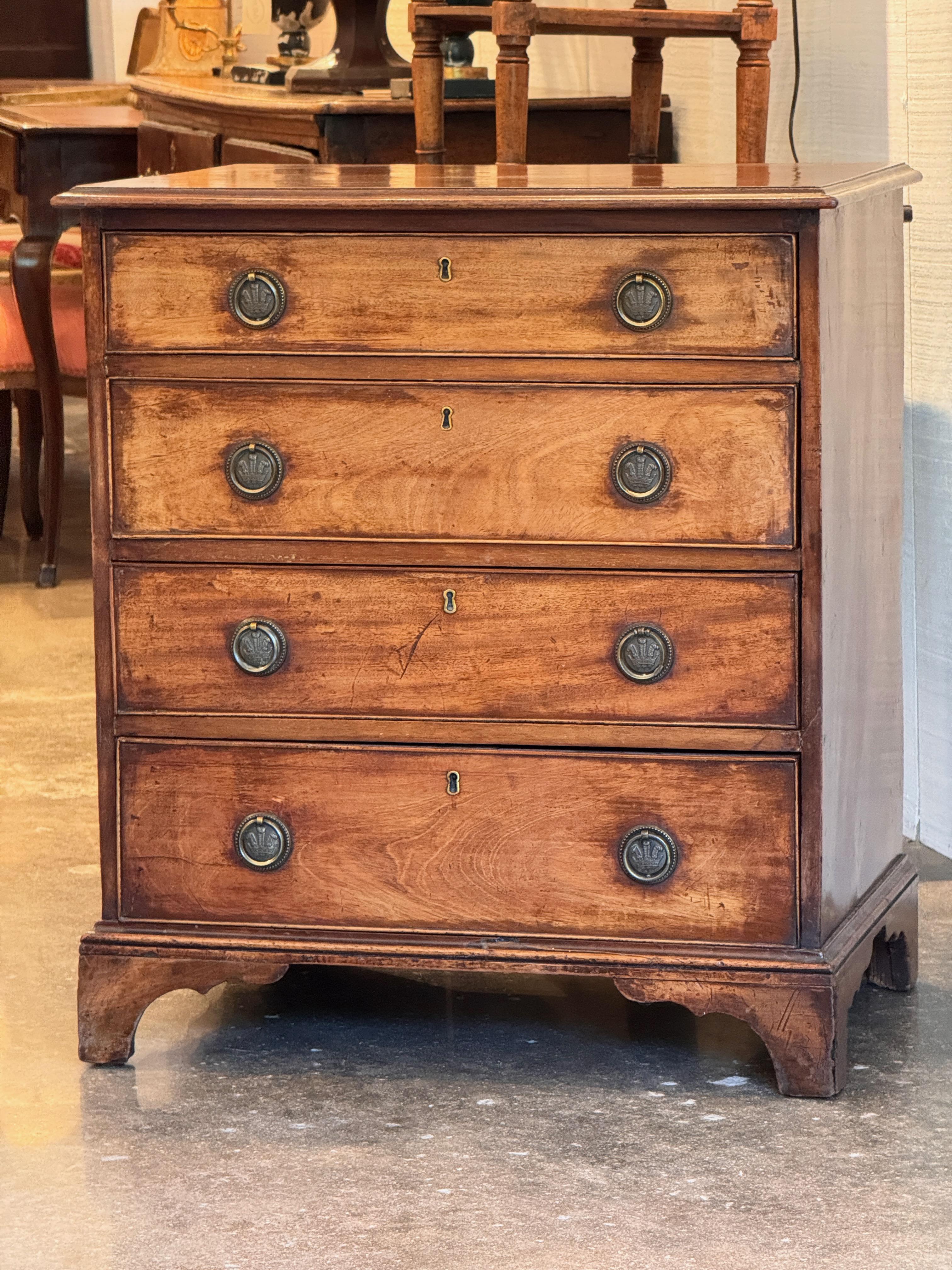Compact George III period chest in mahogany with four graduated drawers, original round brass pulls, and bracket feet. The case features simple molded edges and a clean, functional design typical of late 18th century English furniture.