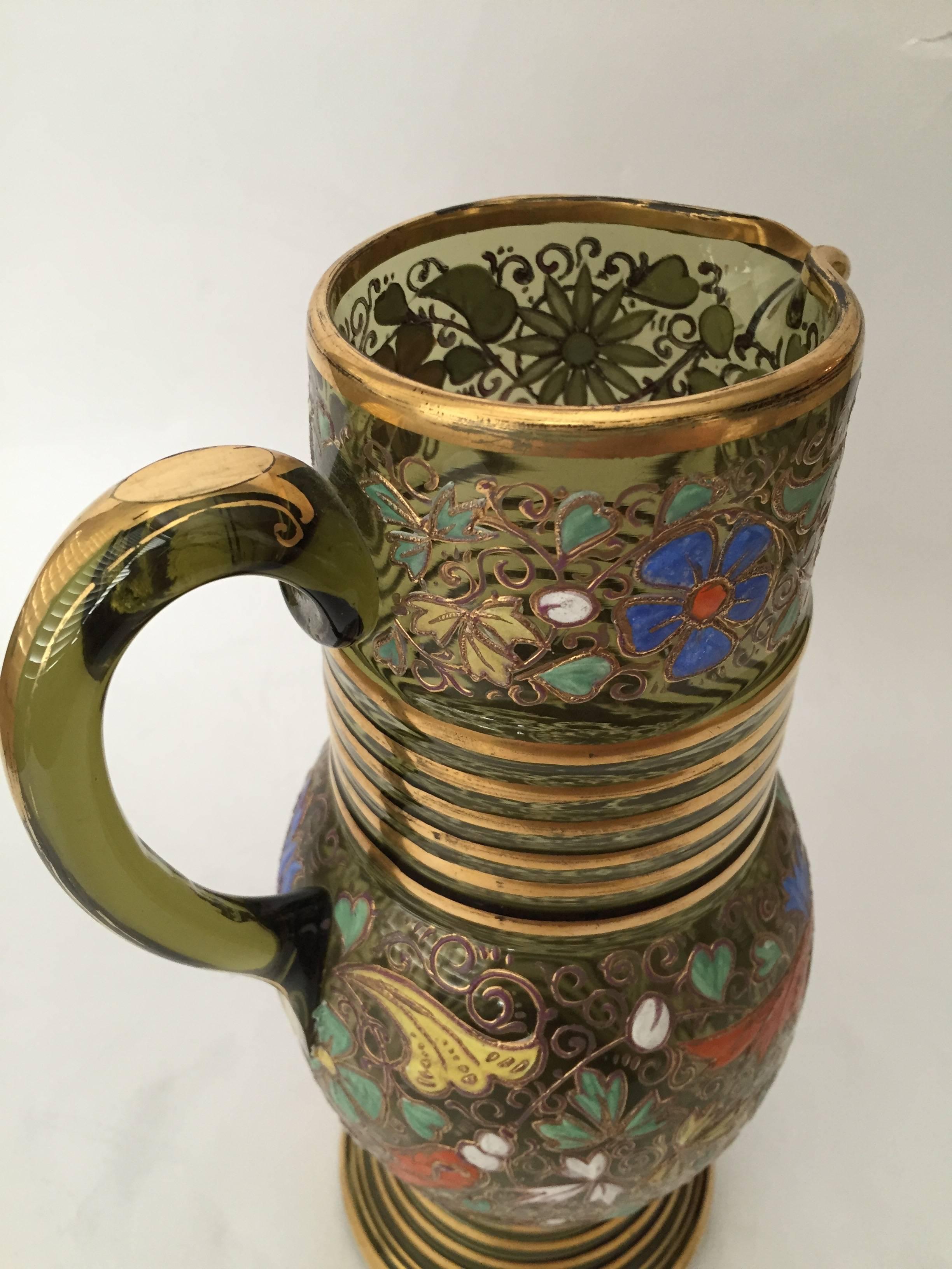 An exceptional Moser pitcher richly decorated with raised paste gold and beautiful polychrome enamels perfect for the holidays and for display on the bar or a cabinet. Moser is still in business, known to be the king of glass, made for the royal