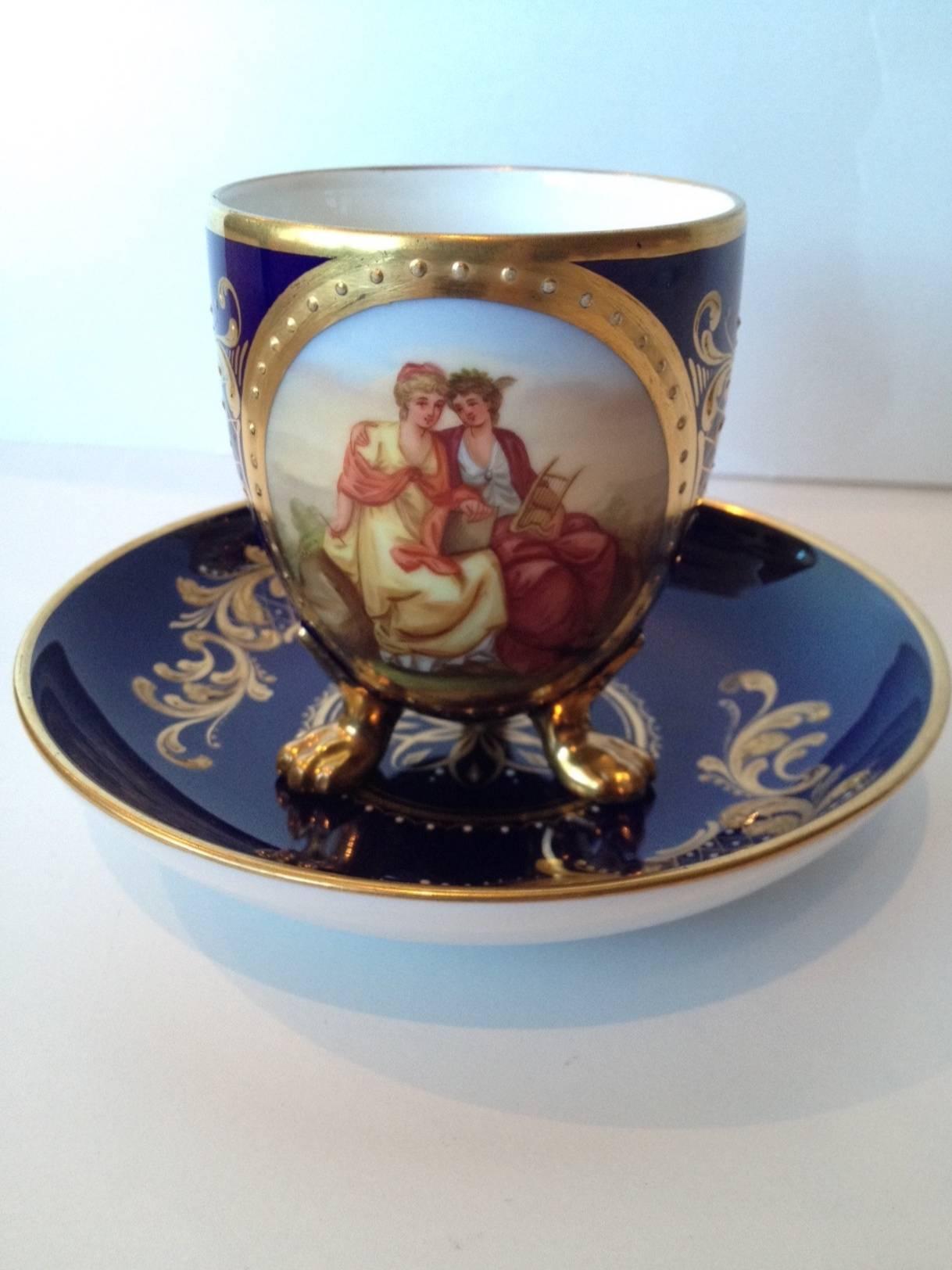It's a nice one that's for sure, lovely hand-painted scene to the center and very richly gilded in raised paste, with enamel dotting highlights. Vienna mark to the bottom of the saucer. In excellent condition with a minor amount of gilt
