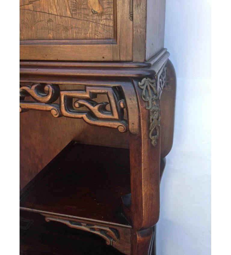 Art Nouveau in taste this wonderful cabinet reminds me of something you would see in the Hearst Castle in a study stuffed with opulent items containing. 
Objects of Vertue. The shape is fantastic the carved dragon protecting the contents and