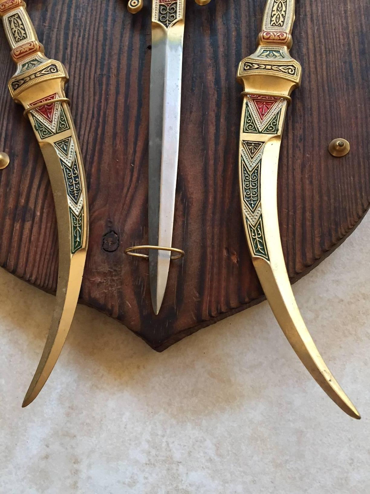 A beautiful set of three letter openers mounted on a carved wooden plaque, with
hand-painted decoration and gold gilt. Perfect for the office, cave or bar. 
In excellent condition.