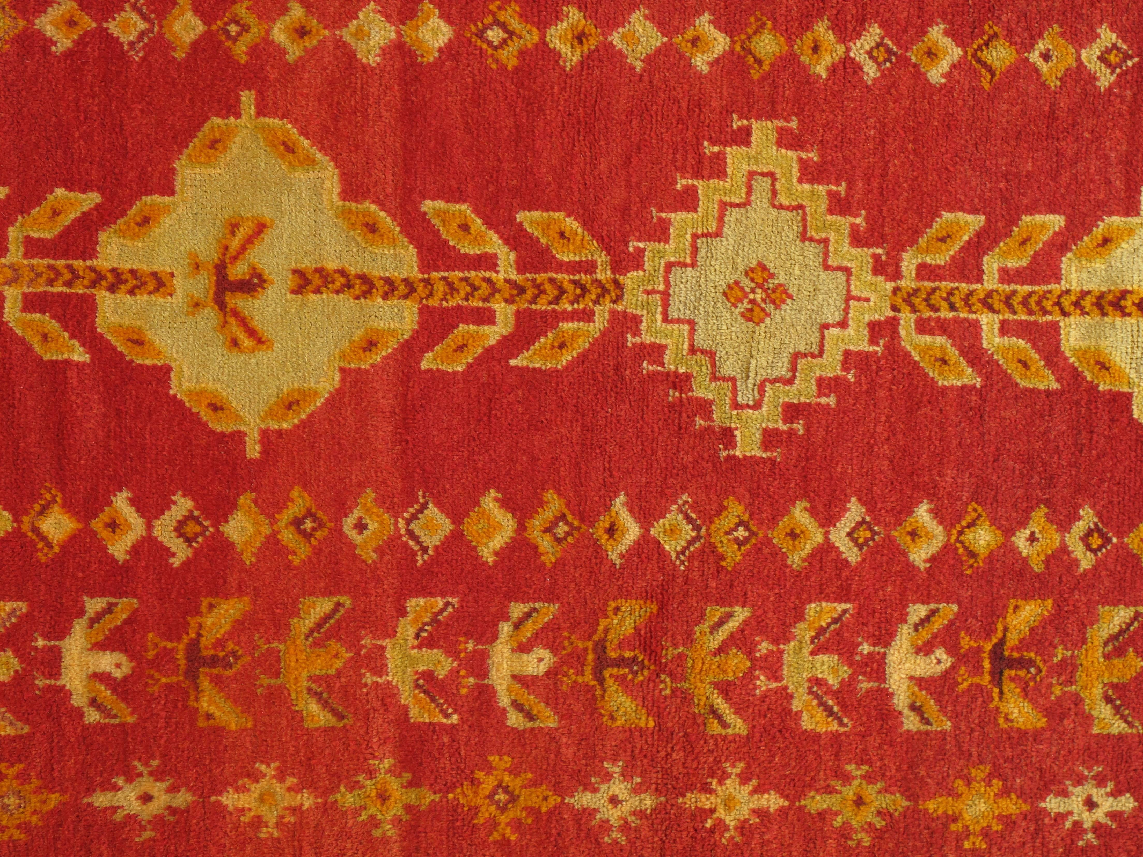 Vintage Moroccan rug, hand-knotted in wool with repeating border motifs on a red field. Measures: 5'6