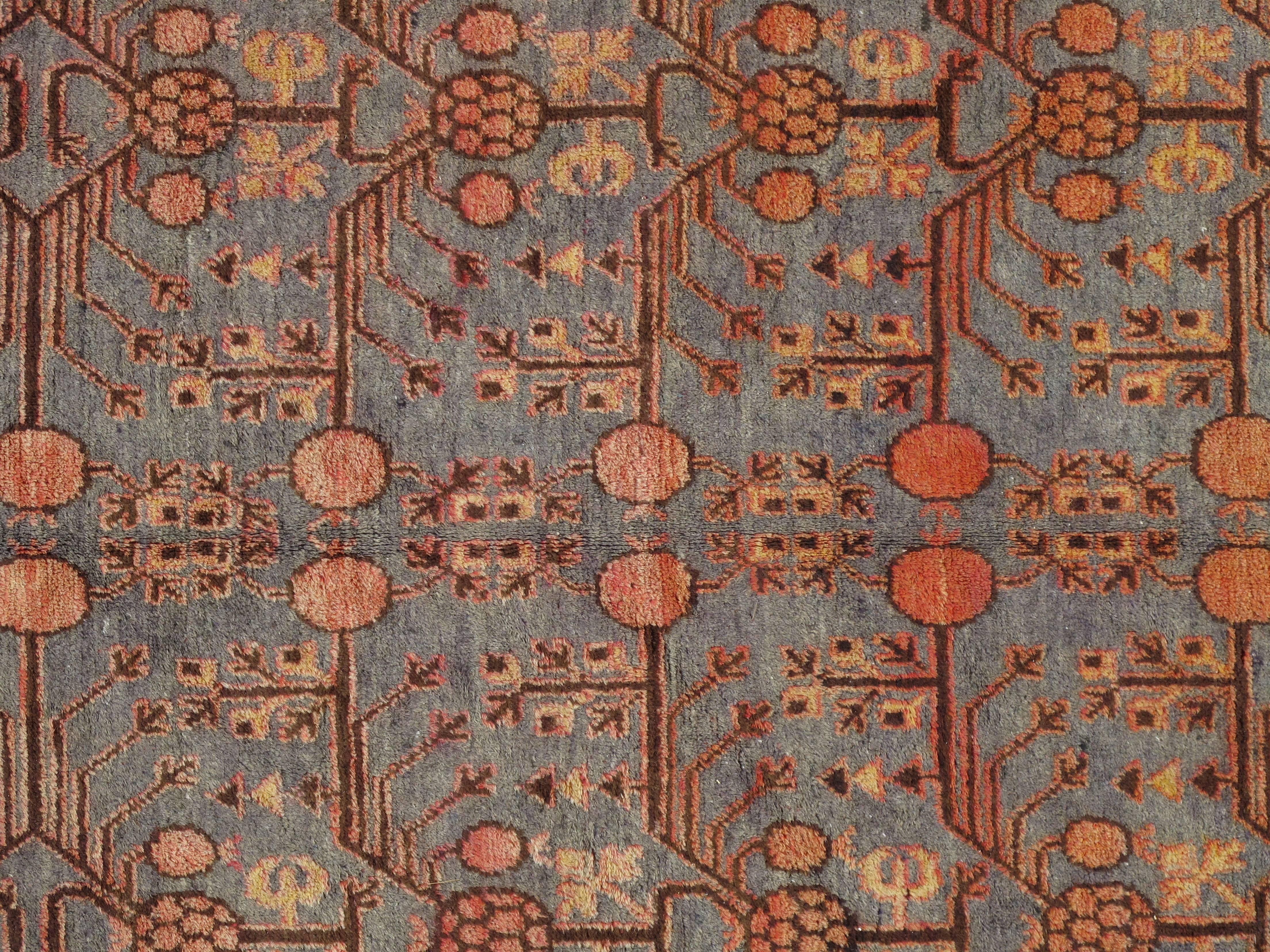 Dieser spektakuläre antike Teppich aus Khotan wurde in den 1920er Jahren gewebt und zeigt ein beispielhaftes Granatapfelmuster, das von traditionellen Bordüren umgeben ist, die den regionalen Stil von Ostturkestan verkörpern. Strahlende Wolken- und