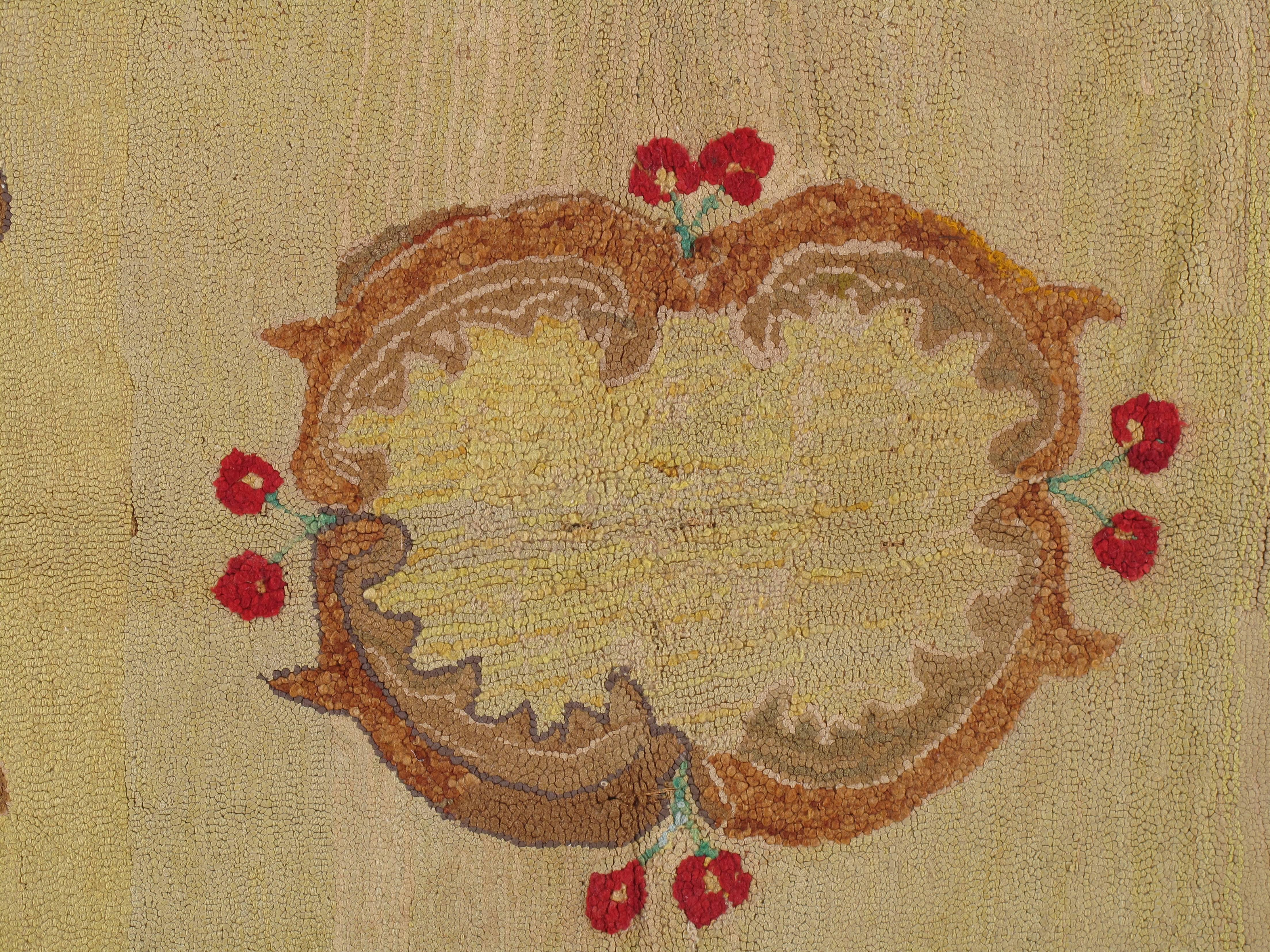 American hand-hooked wool rug of brightly colored floral bouquet on oval, pale yellow background, framed in black wool surround, with small floral motifs, circa 1900. Size 5'10