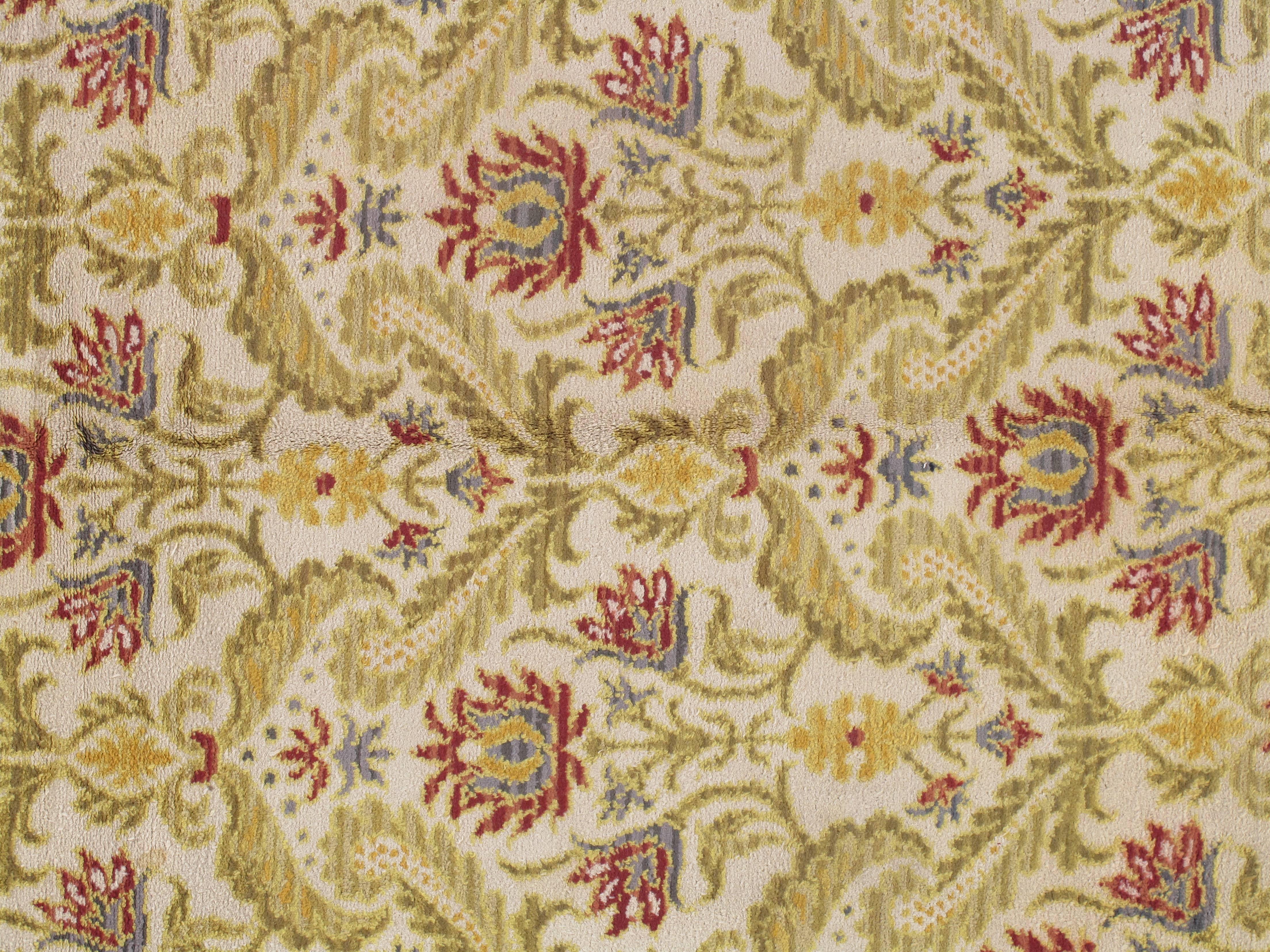 This is a hand-knotted, finely woven antique Portuguese carpet, having a all-over floral pattern. Measures: 10 x 13.