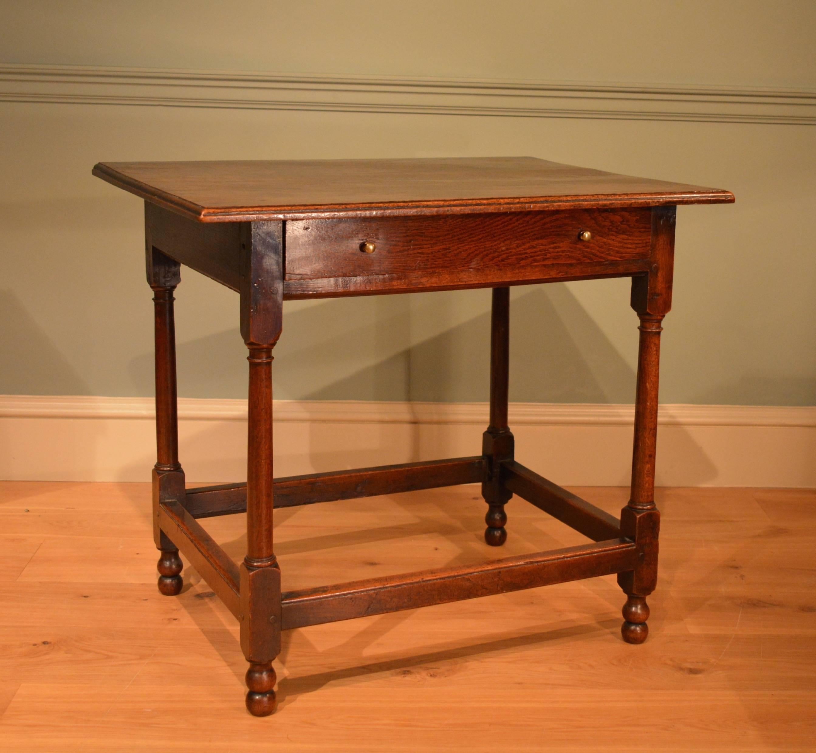 An oak one drawer side table standing on turned legs united by stretchers over it's original double turned feet.
