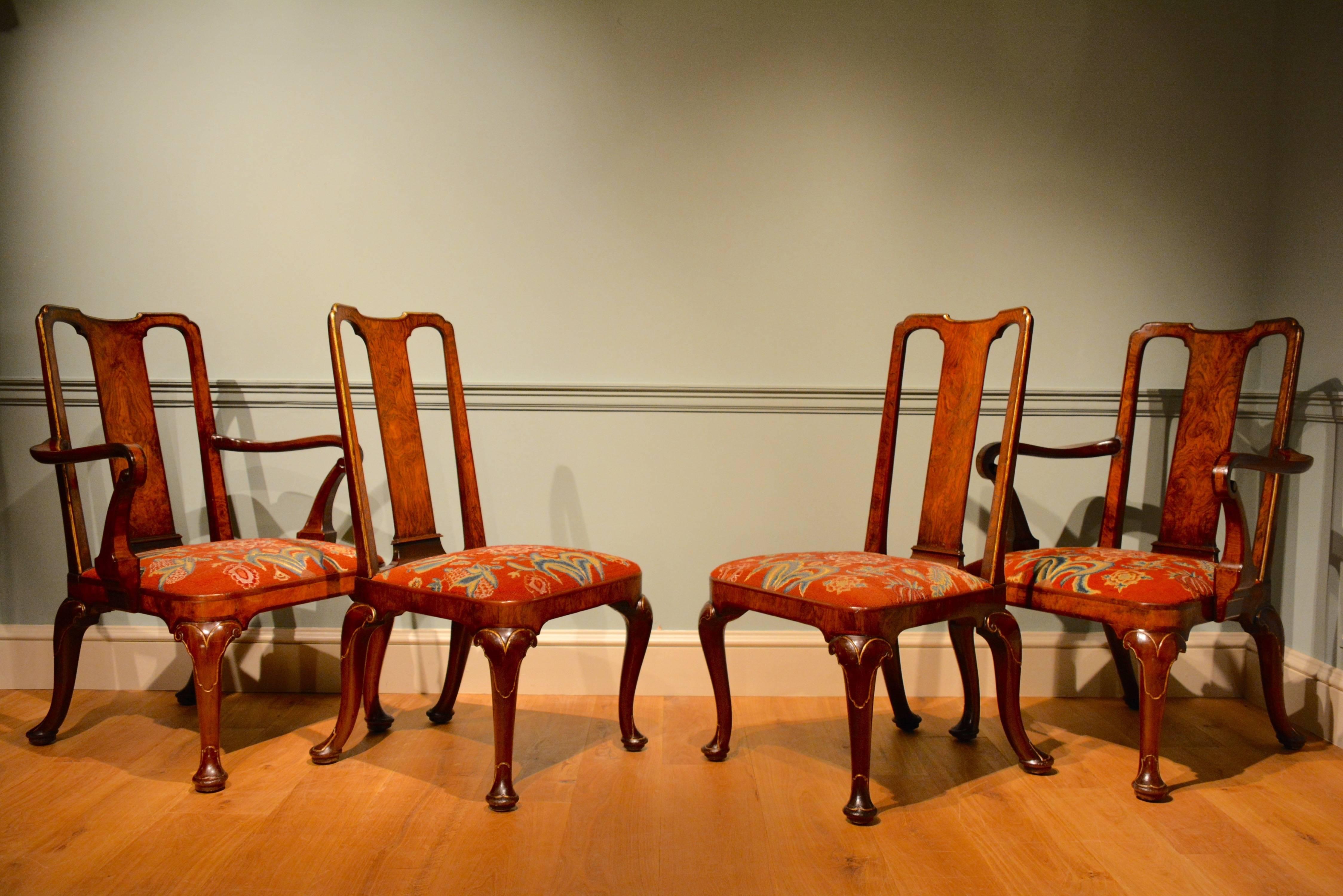 A fine set of four George II mahogany chairs comprising of a pair of armchairs and a pair of side chairs. These finely drawn chairs are constructed of mahogany with walnut veneered panels to the back and crossbanding throughout the frames, with