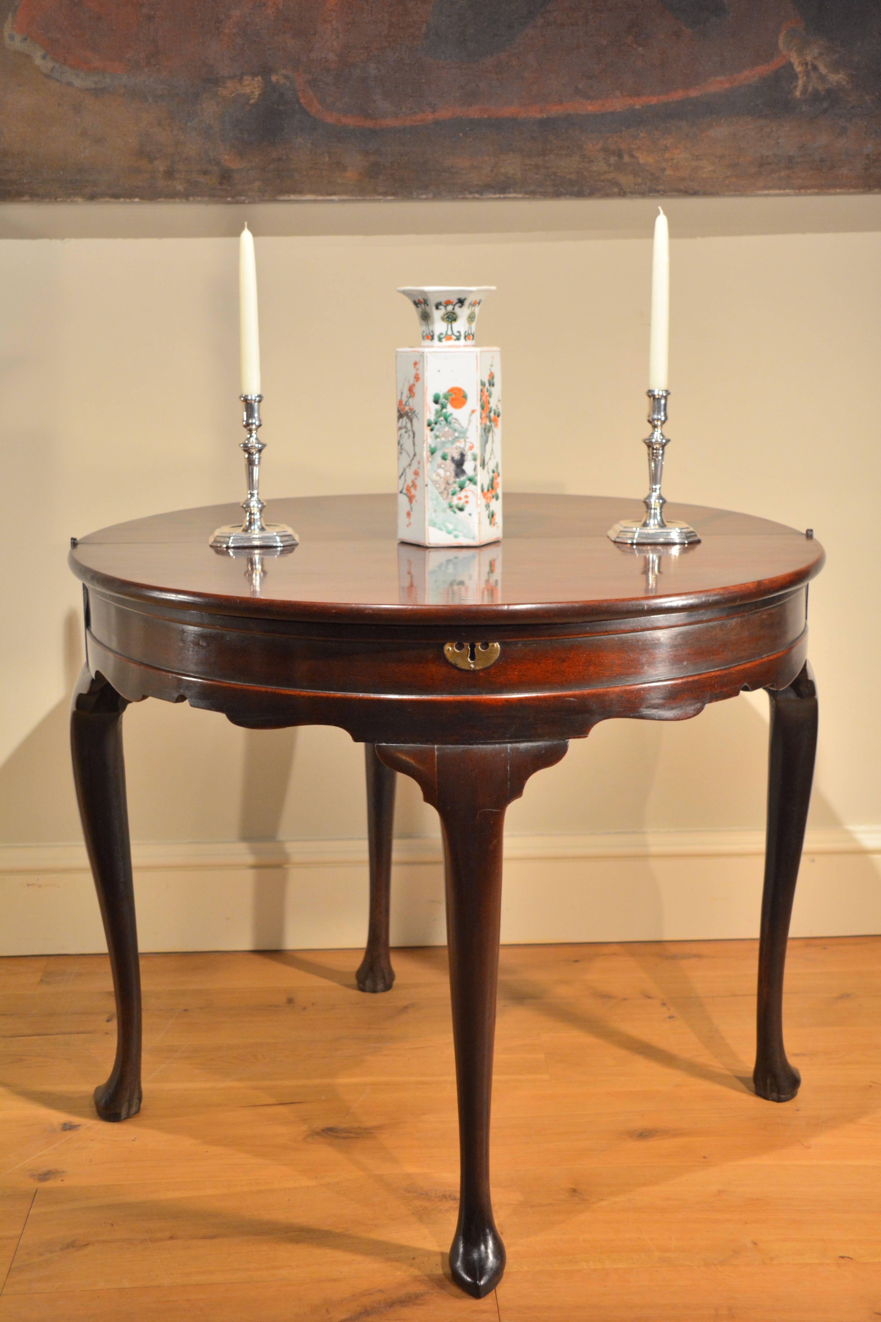 A George II mahogany half round tea table standing on well-drawn cabriole legs ending in slipper toe feet.
    