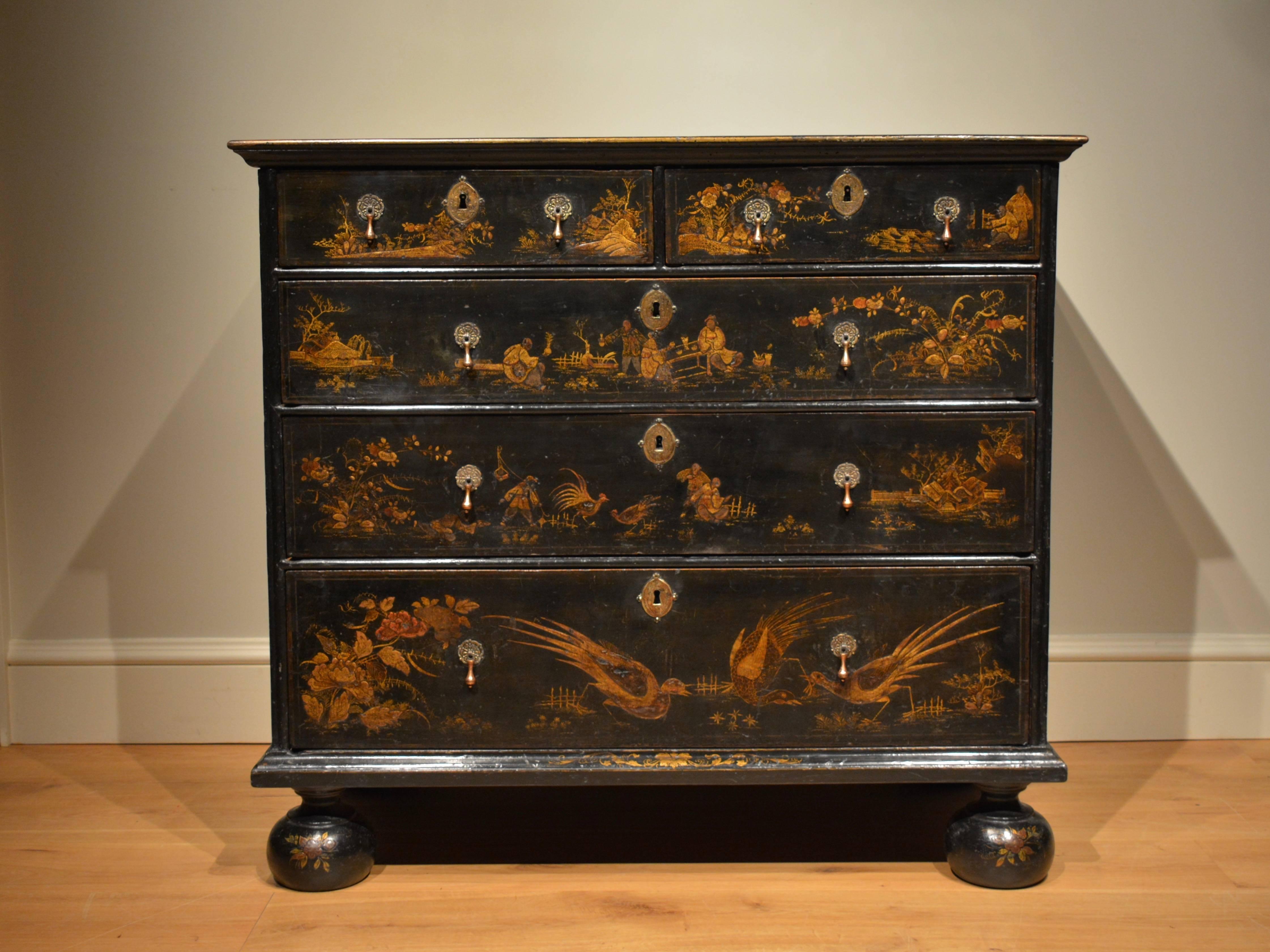 A fine quality japanned chest of drawers, decorated overall in gold and red against a black background depicting birds, people and foliage. This chest retains all it's original decoration, including that of the top, and also it's original brasses,