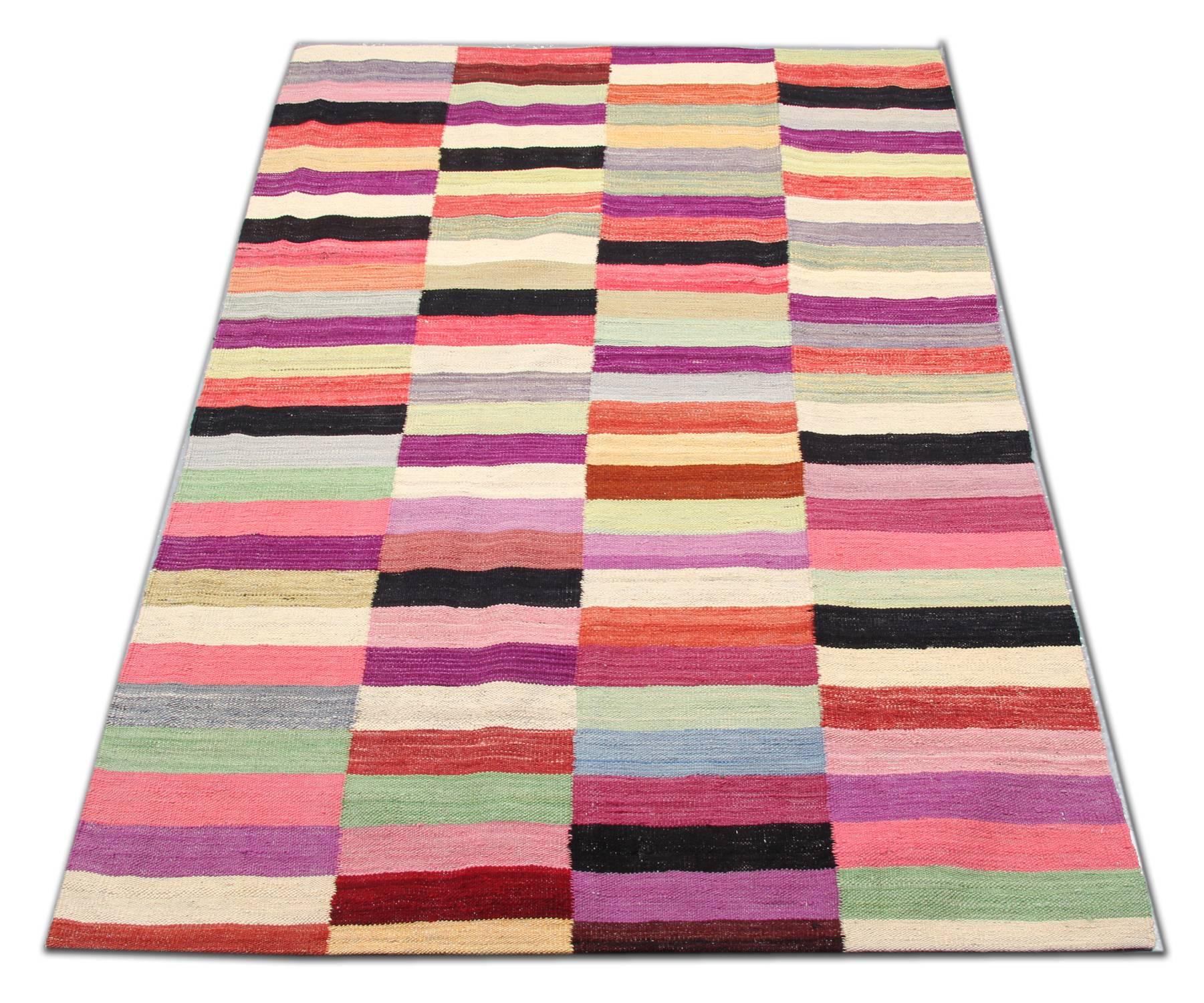 These striped wool rugs derive from Afghanistan. It is entirely hand woven rug with the best wool and cotton. Only organic dyes have been used for the production of this flat-woven rug. This striped rug shows a varied palette, including light pink,