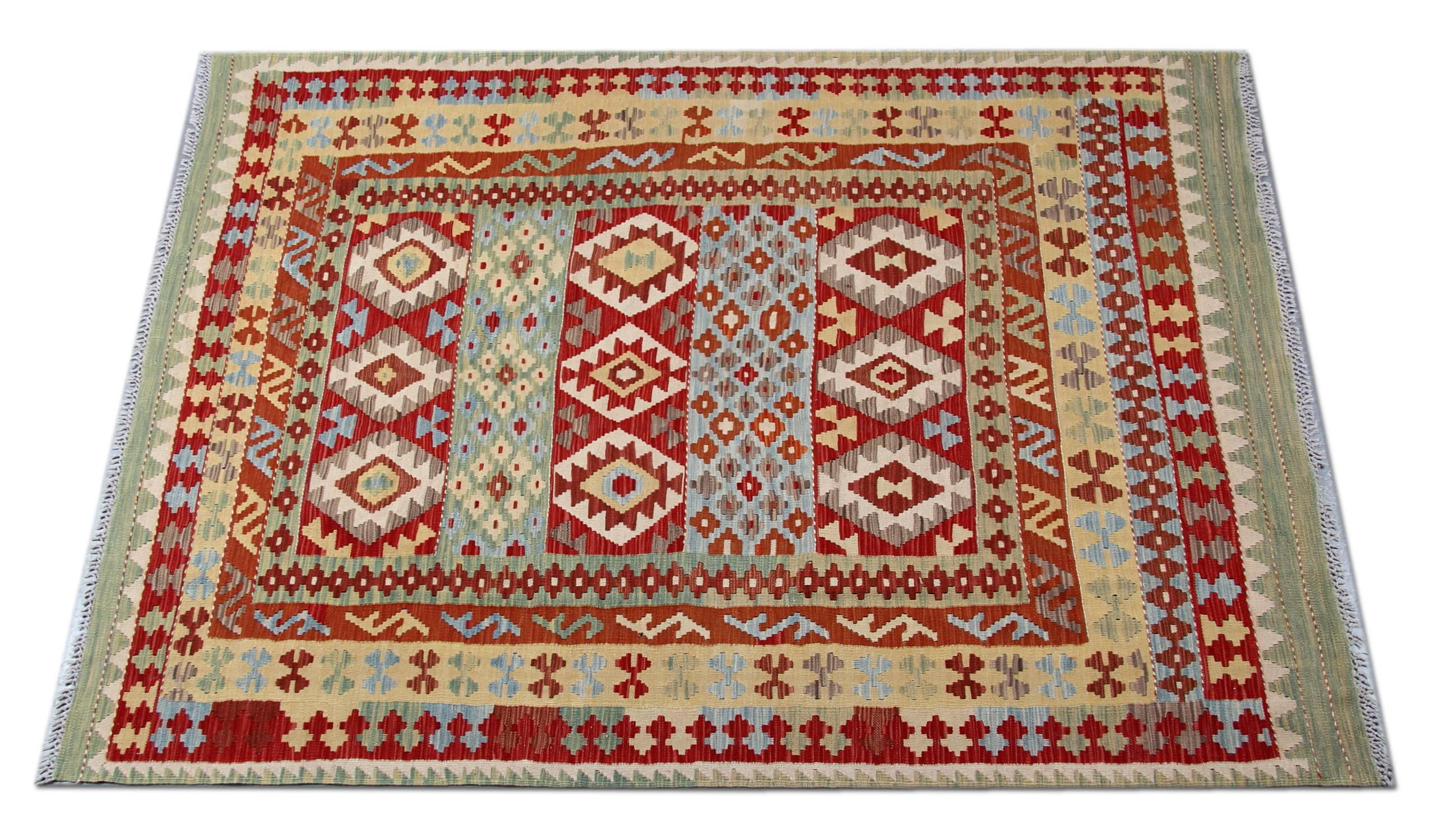 This tribal rug is a Kilim which derives from Uzbek and Turkman tribes. The flat weave rug is completely handmade by using the best wool and cotton. In addition, only organic dyes have been used for the production of this red rug. The designs derive