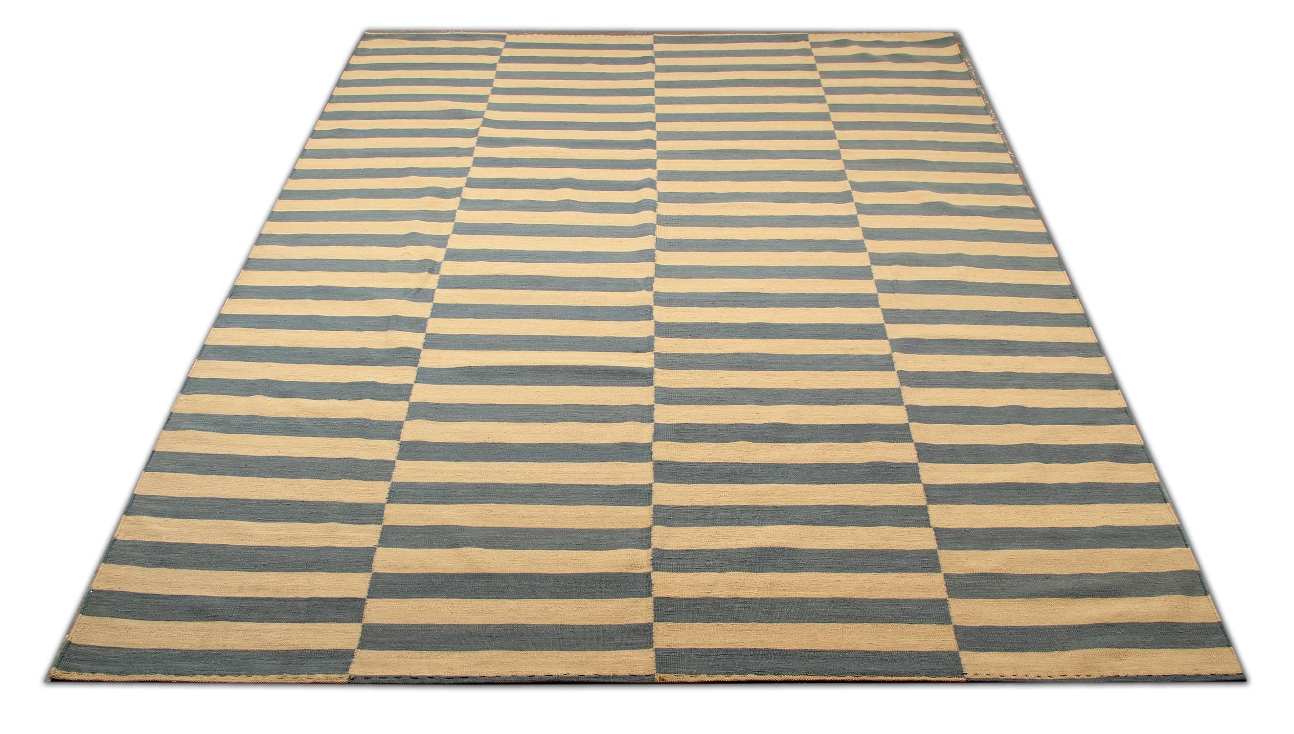 This striped rug is 100% handmade in Afghanistan. It is a Kilim woven rug and therefore it is a flat-woven rug. The materials used for this carpet rug are wool and cotton and the dyes are only organic. This blue, yellow and grey rug is hard-wearing