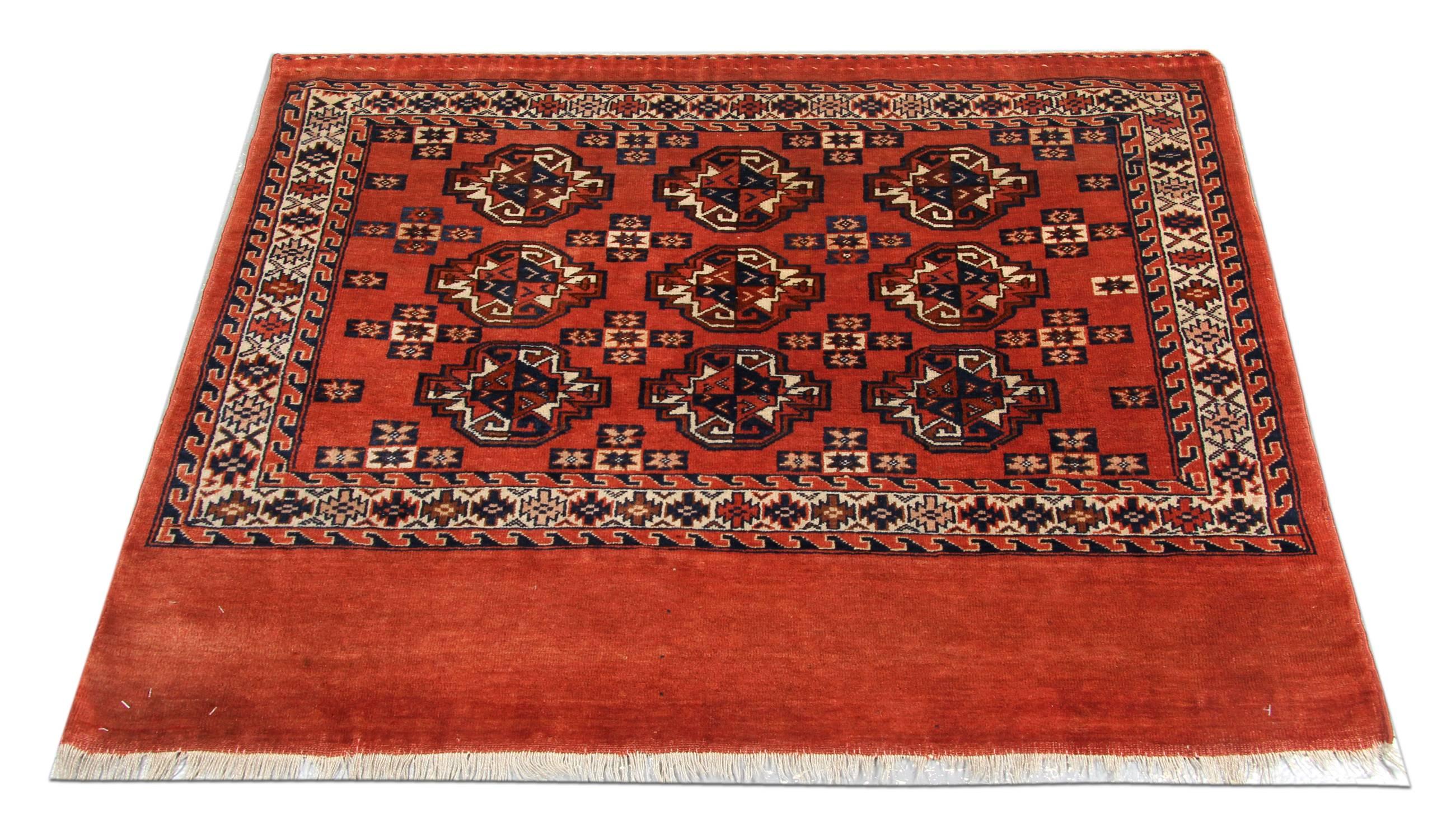 This handmade carpet red rug is a kind of beautiful hand-knotted Turkmen carpets with geometric rug pattern and very elegant tribal and geometric rug design. These wool rugs have vibrant natural dyes. The combination of rust red, orange, and gold in