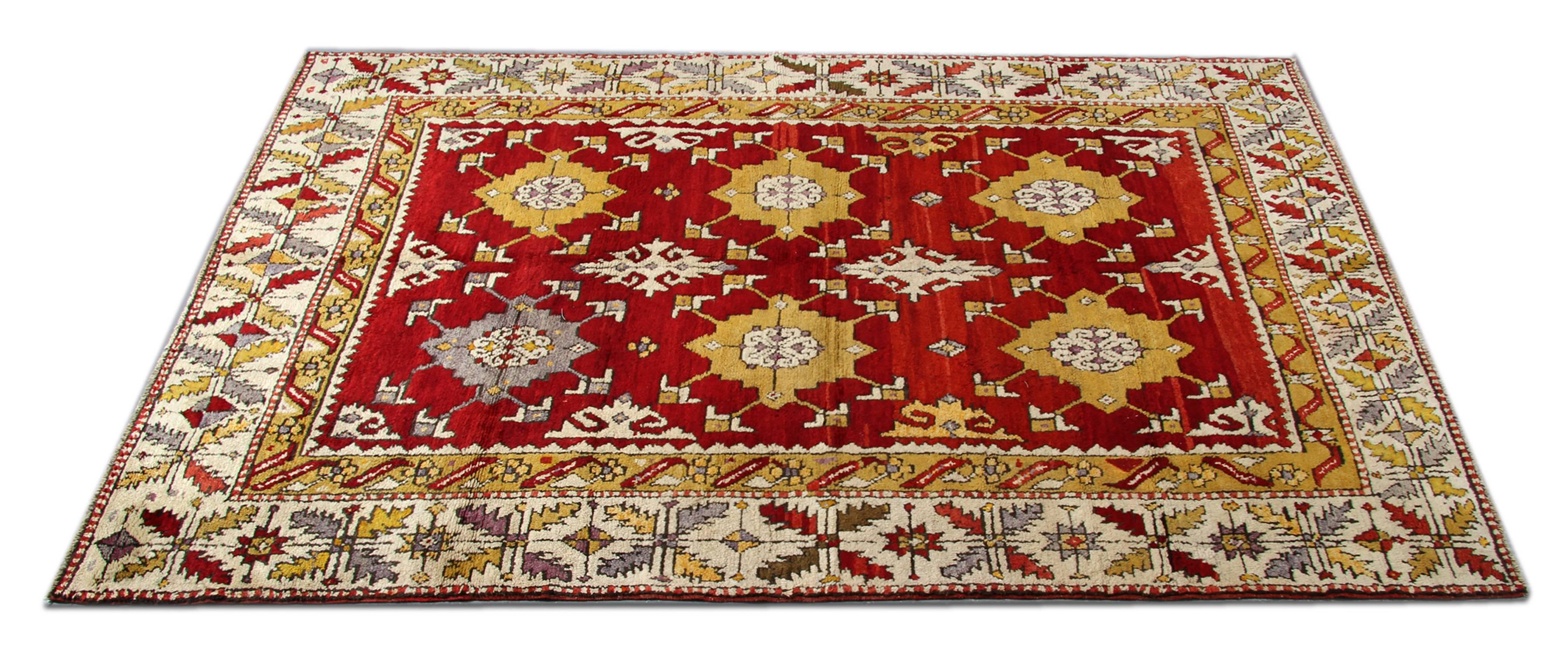 Alter handgeknüpfter Teppich aus Anatolien mit rotem Teppichgrund und kontrastierenden Gold- und Grautönen, die in dem geometrischen Muster frei fließen. Dieser traditionelle Teppich aus zentraler Tukey in einem ausgezeichneten Zustand und kann ein