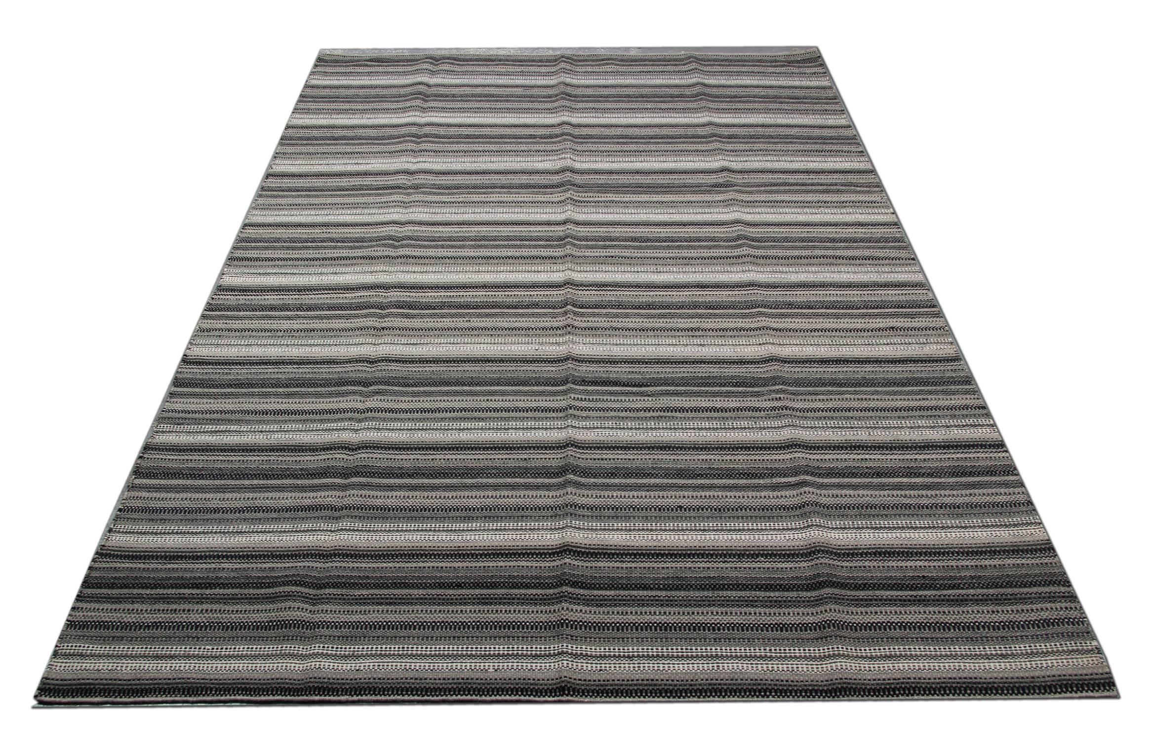 This fantastic wool rug is a handwoven Kilim constructed in India, 2000. It features a simple yet eyecatching stripe design with colours of white and Grey. Both the colour and design of this piece make it the perfect rug for any room in your