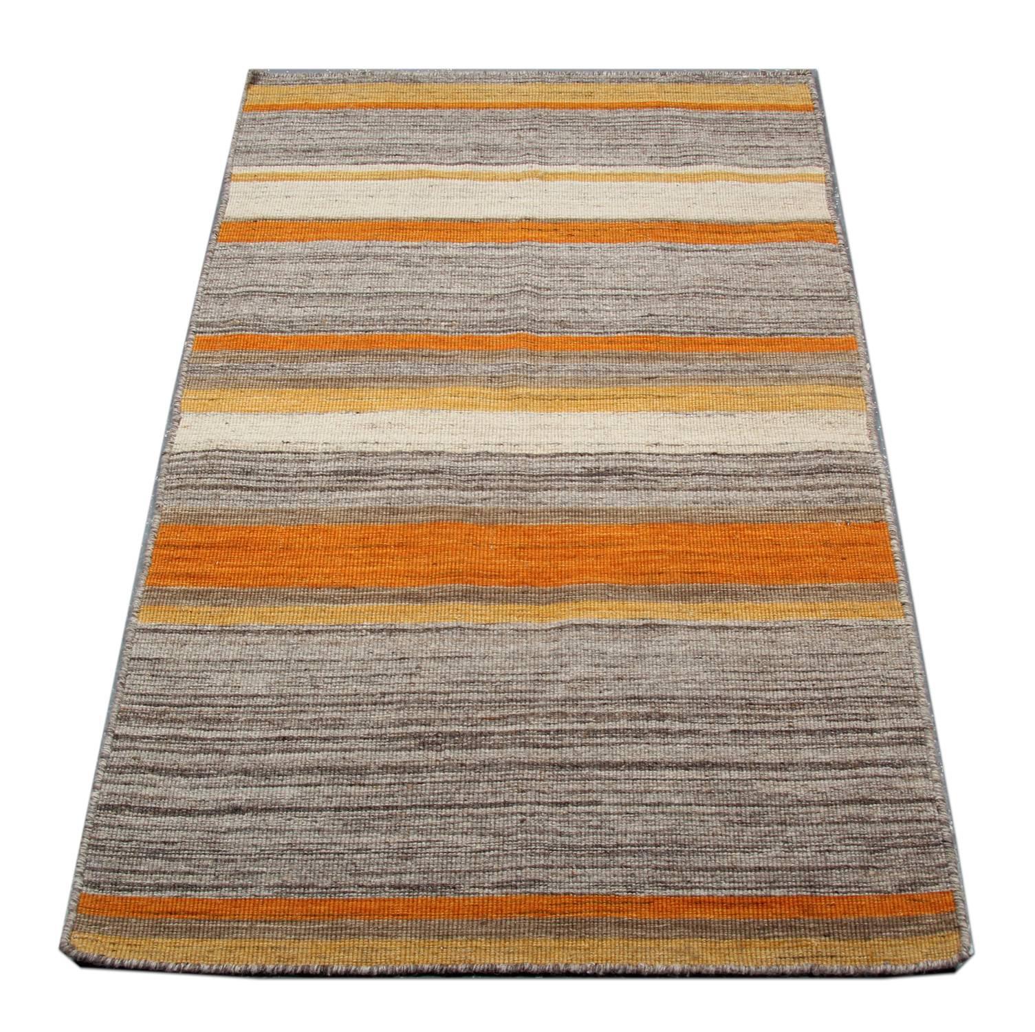 This fantastic wool rug is a handwoven Kilim constructed in India, 2000. It features a simple yet eye-catching stripe design with colors of white and Grey. Both the color and design of this piece make it the perfect rug for any room in your