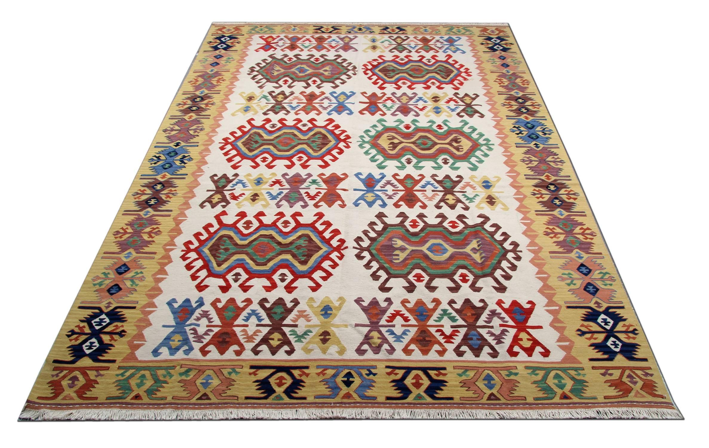 This fine wool area rug has been woven by hand and features a fantastic geometric medallion woven on a simple ivory cream background with a decorative surrounding design. Woven in accents of cream, green and yellow accents. Symmetrically woven with