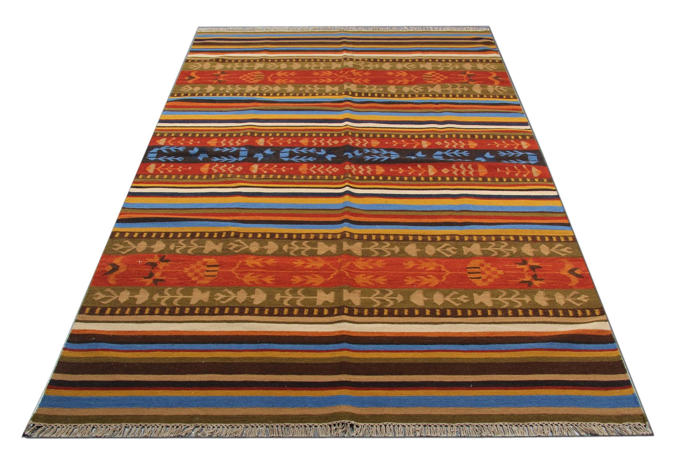 This beautiful wool area rug has been woven by hand and features a fantastic stripe geometric design. Woven in accents of brown, blue, green, beige and rust. Symmetrically woven with sophistication this piece is sure to uplift any room it is