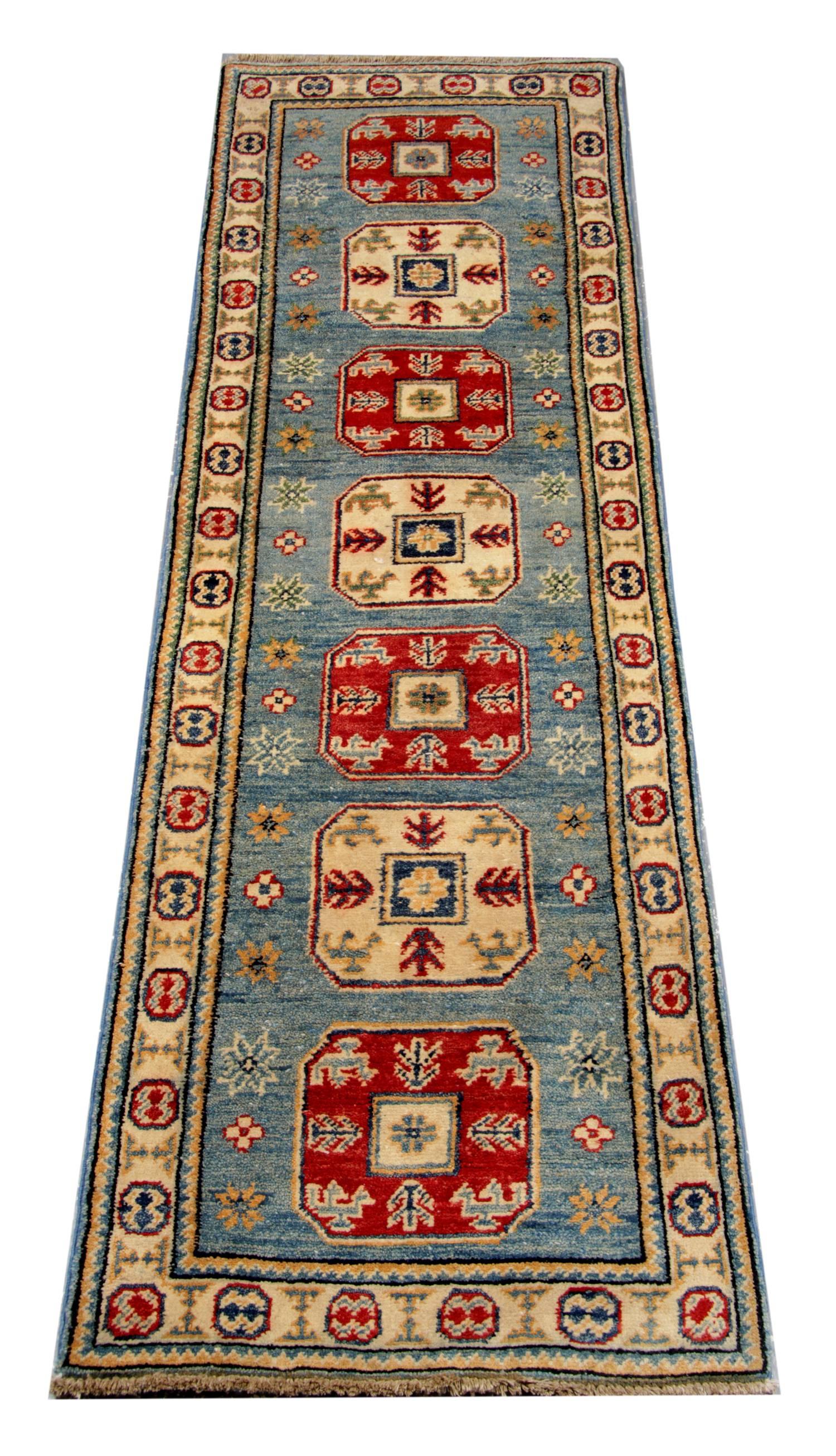 This new traditional hand woven rug comes in a striking color combination of bright red, navy, light blue, sea blue, cream and caramel. These patterned rugs are influenced by the Caucasian designs of Northern Persia. This soft blue rug has cream