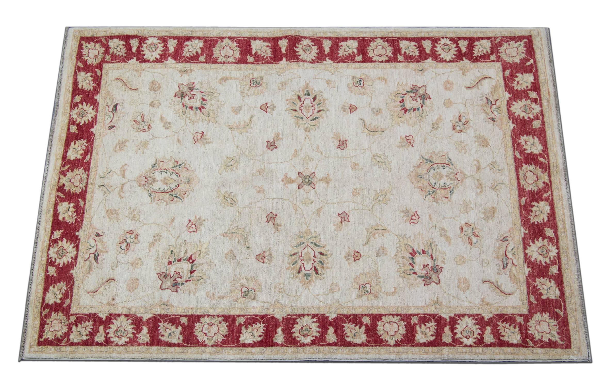 Ce tapis blanc doré avec une magnifique bordure rouge est un tapis tissé Ziegler Sultanabad fabriqué sur nos métiers par nos maîtres tisserands en Afghanistan. Ces tapis faits main sont tissés avec des teintures végétales naturelles et de la laine