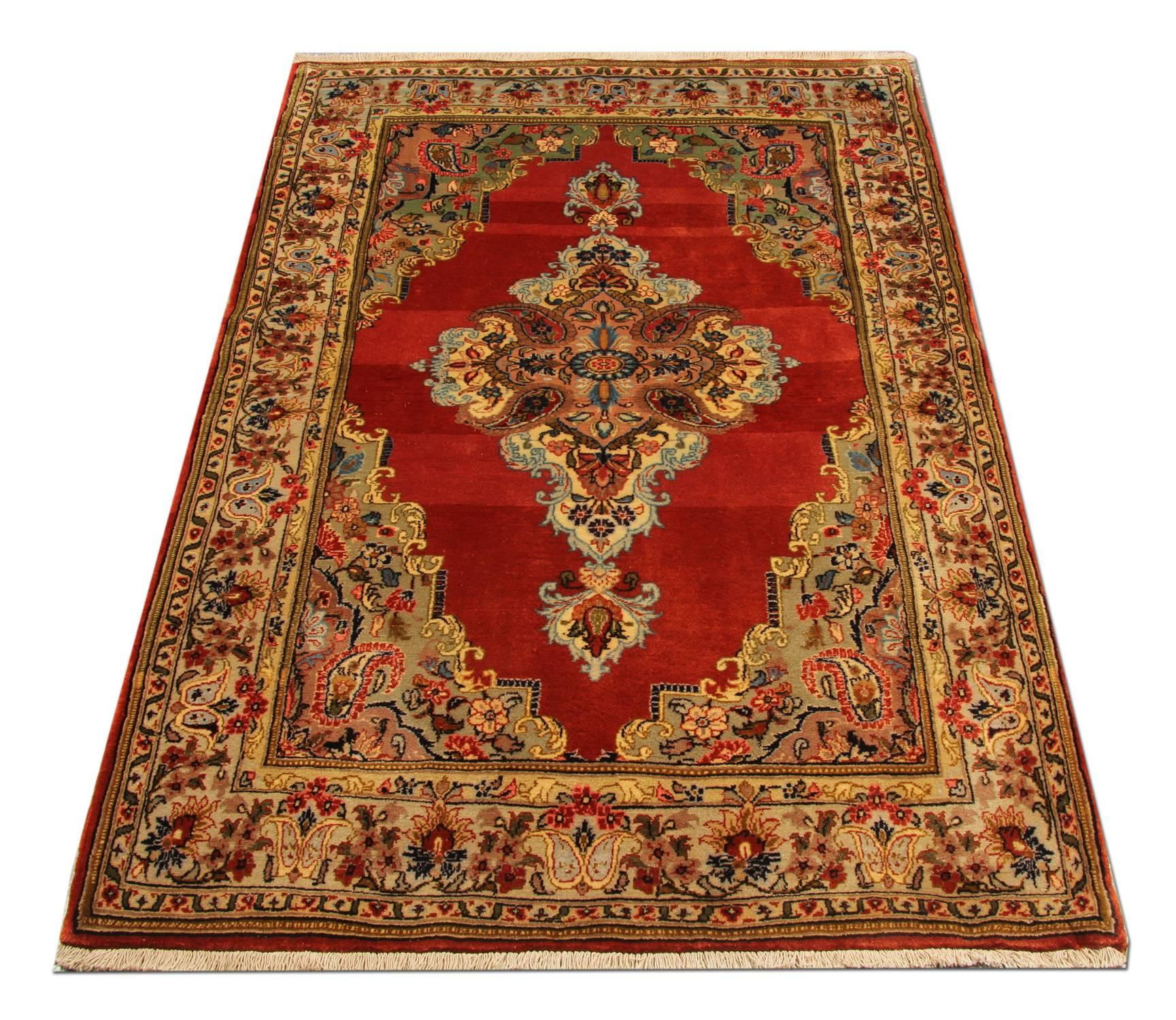 This elegant handwoven wool area rug features a traditional medallion design, woven in the 1950s. This piece is sure to uplift any room it is introduced too. The highly-decorative central design and the border have been intricately woven and make it