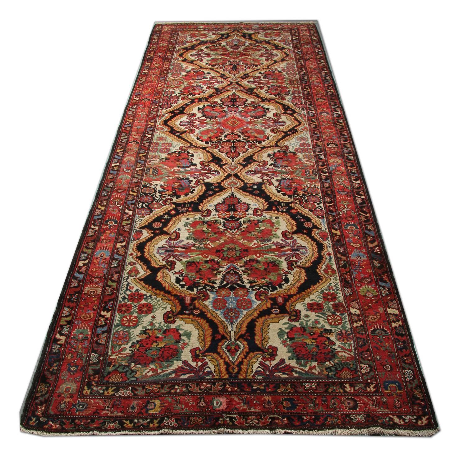 This fine wool rug was handwoven in Caucasia, Azerbaijan, in 1940. featuring a floral botanical central design hand-knotted with handspun wool and cotton. The vibrant colours have been dyed using vegetable dyes, rich reds, and greens sit side by