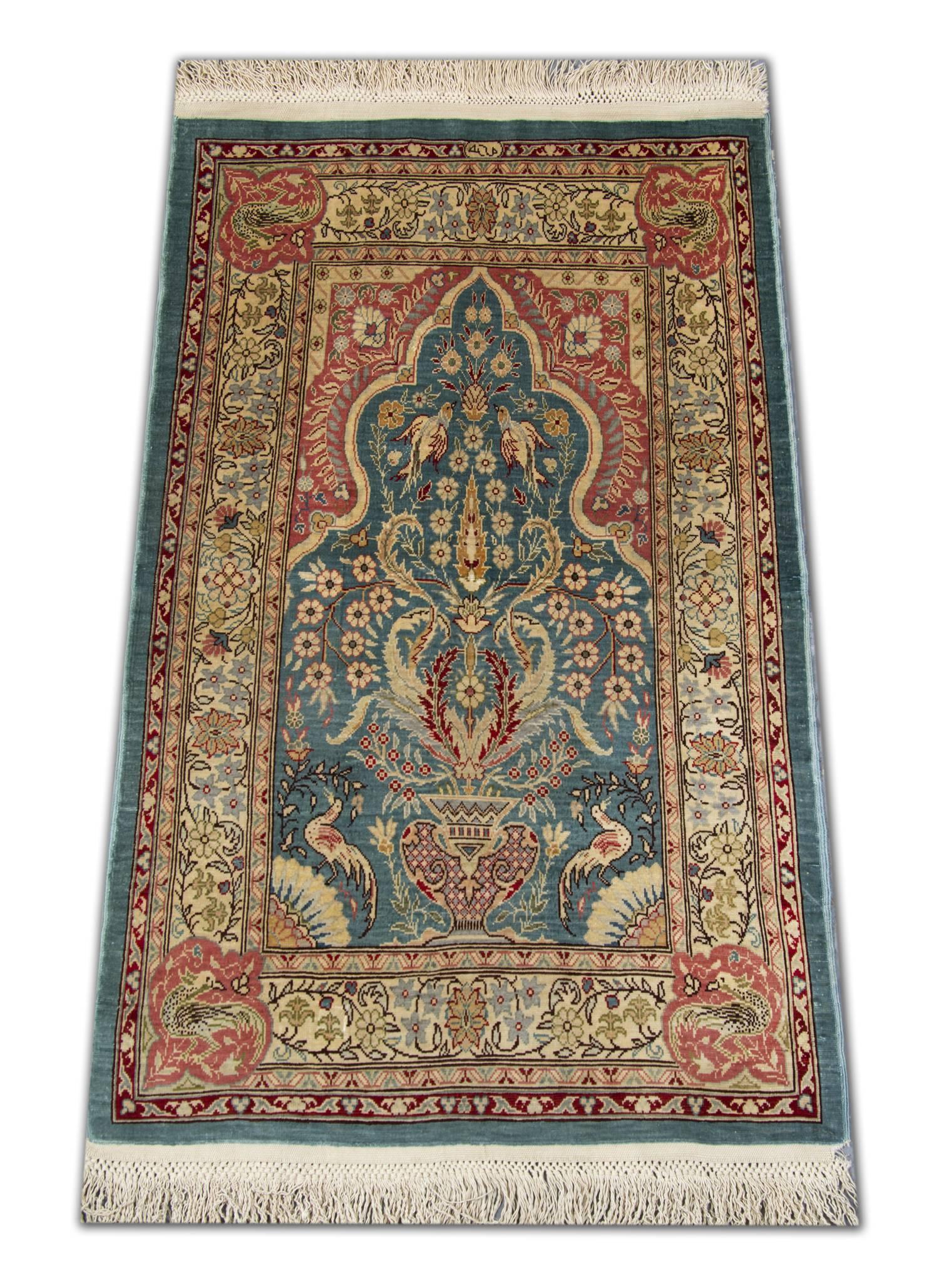 Turkish silk Hereke Oriental rug. This Fine hand-knotted carpet features a lustrous short silk pile with a vase design at one end of the blue center field, beautiful flower heads at center and an arch at the other end. The central frame is enclosed