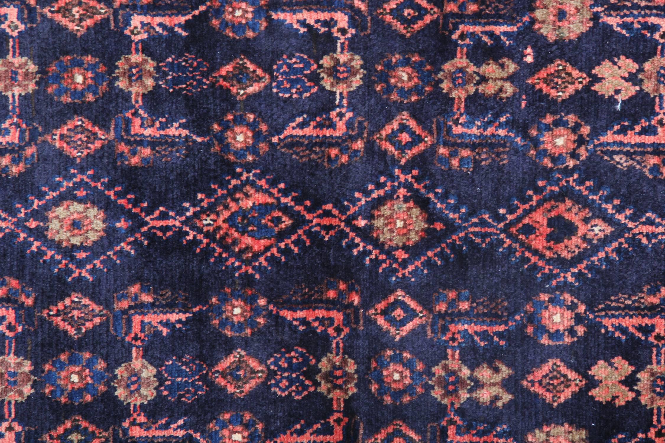 This elegant tribal rug was woven by hand with fine locally sourced materials and a fantastic design. The asymmetrical pattern has been intricately woven on a deep blue background with rich red and pink accents. A decorative border then frames this.