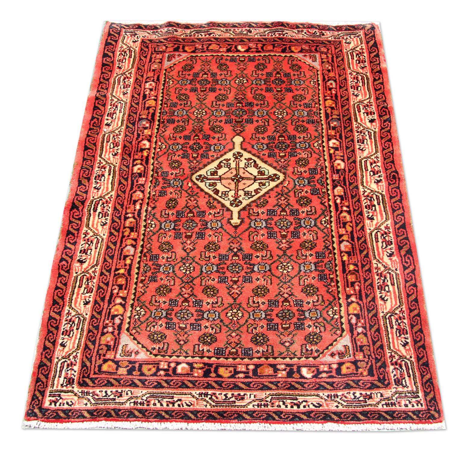 This fine wool rug was handwoven in Turkey with locally sourced materials in the 1970s. The central design features an elegant cream diamond medallion woven on a rich red background with a surrounding decorative design and a border woven with
