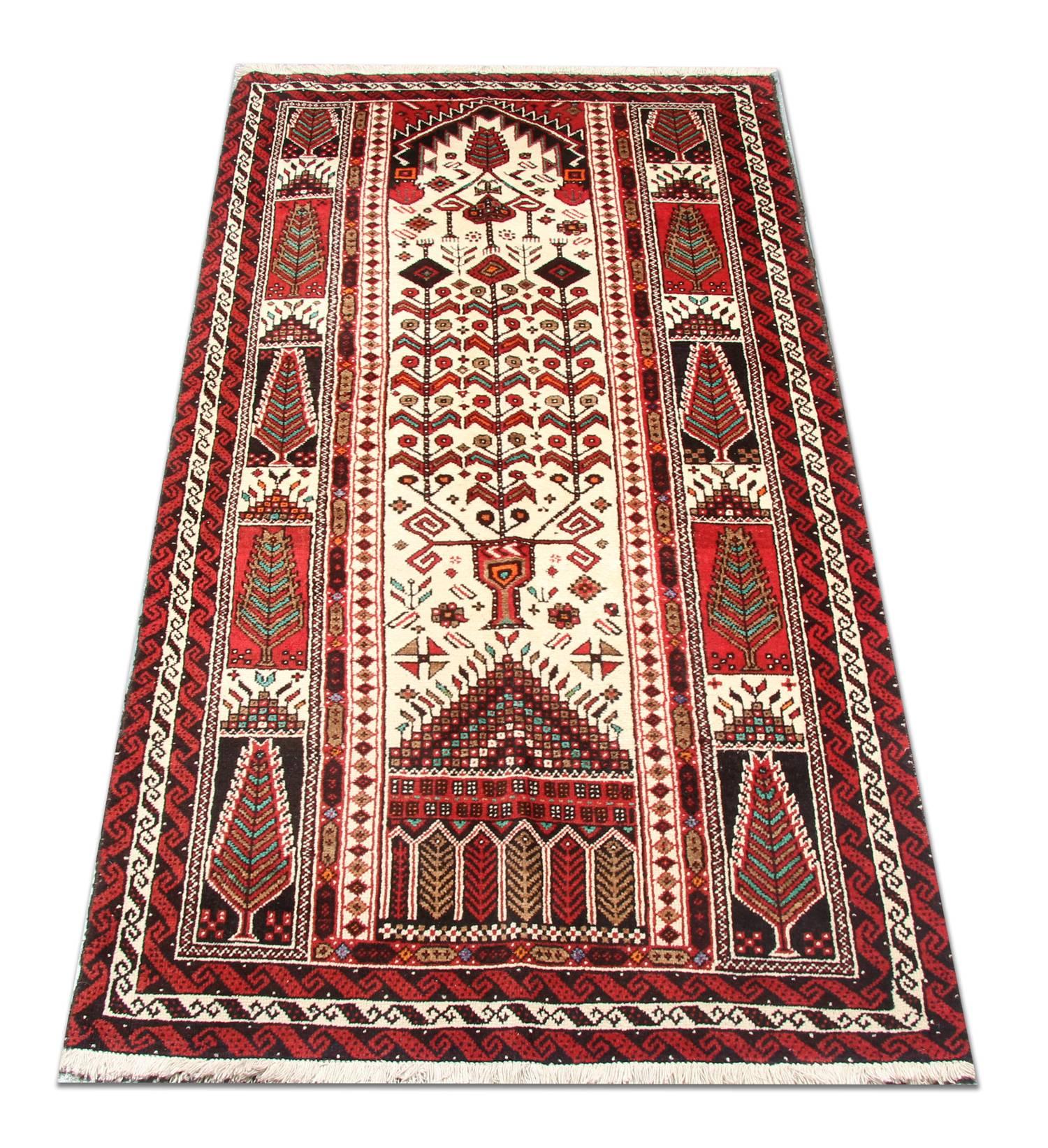 This fine wool rug was woven by hand in Afghanistan in the 1990s with the finest hand-spun wool. The central design features a traditional tribal motif design with an ivory background and accents of red, blue and rust that make up the tribal