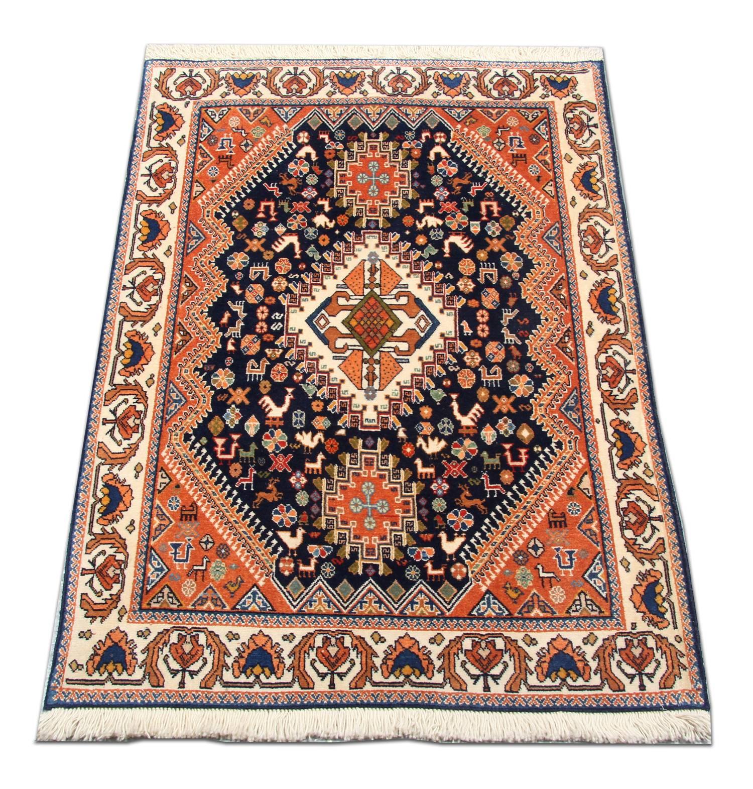 This beautiful wool area rug has been intricately woven by hand with a delicate medallion and motif design. The central design has been woven on a deep blue background in accents of orange, green, cream and grey. Featuring animal motifs and