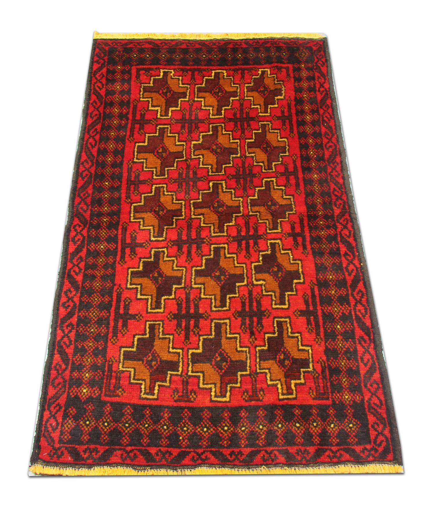 Dieser elegante handgewebte Teppich besteht aus einem zentralen Allover-Muster mit einfachen, asymmetrisch gewebten Medaillons. Es hat einen roten Hintergrund und senf- und braunfarbene Akzente, die die geometrischen Motive bilden. Dies wird dann