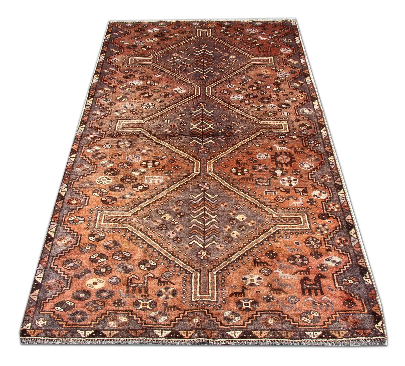 This rustic wool rug has been woven with a fantastic diamond medallion design. Three medallions decorate the centre of this piece with a surrounding design adorned with floral and animal motifs with a geometric repeat border. This rug would make a