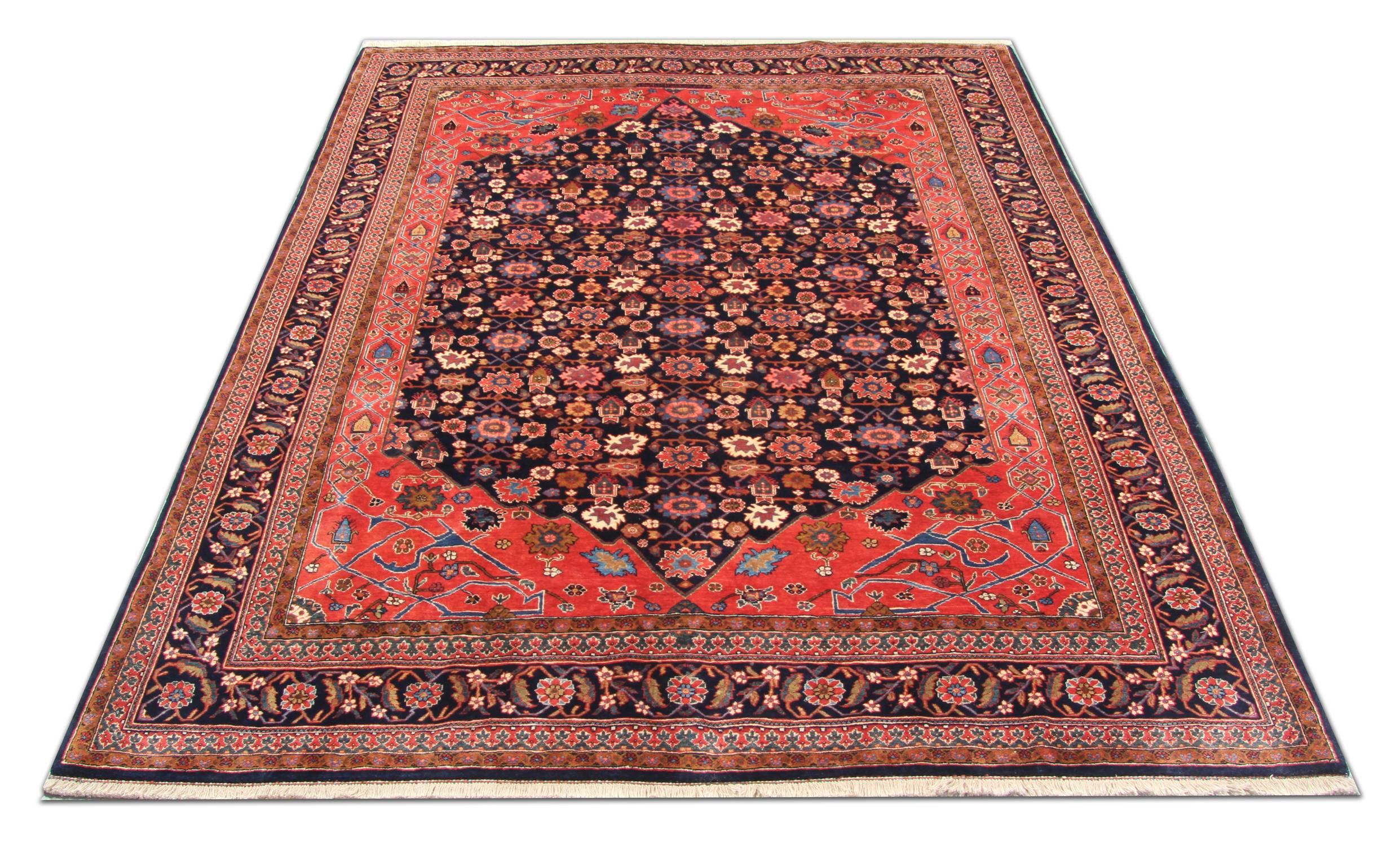 This highly-decorative wool rug has been woven with a fantastic central design woven on dark background in accents of pink, blue and orange. An intricate repeat pattern border encloses the central design. Layered with detail, this beautiful wool